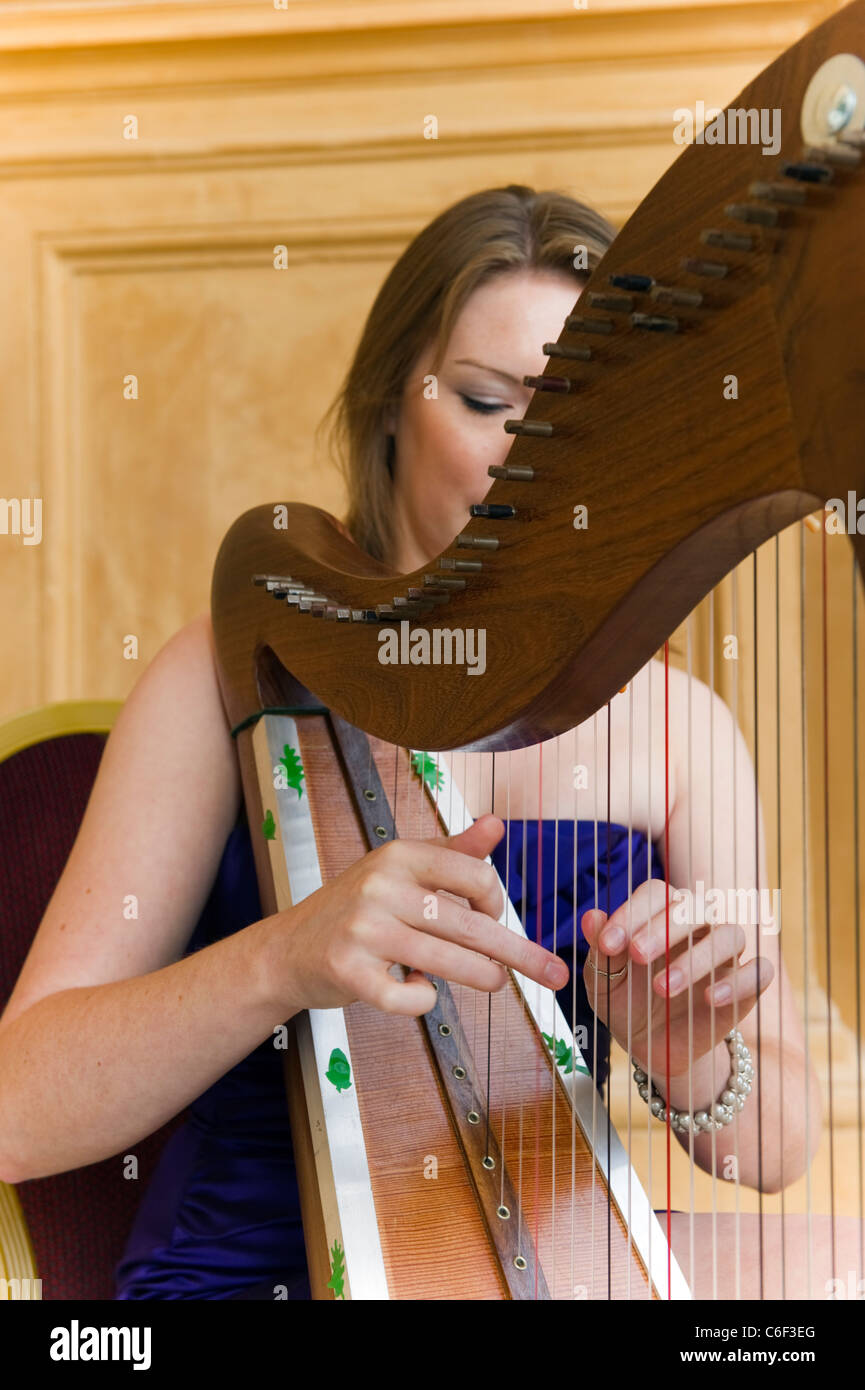 Jeune femme musicien jouant de la harpe Banque D'Images