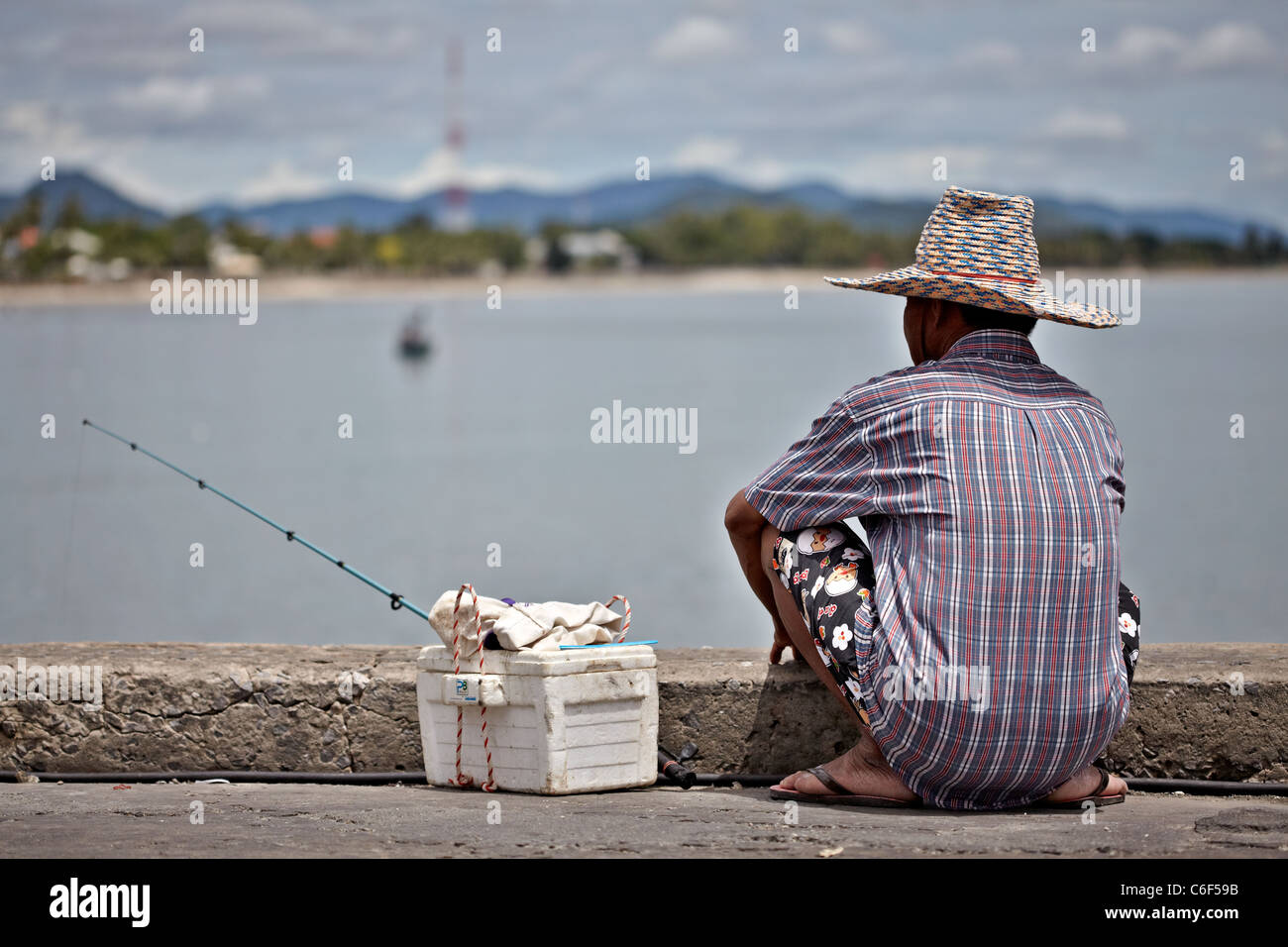 Seul pêcheur à un lieu au bord du lac. S. E. Asie Thaïlande Banque D'Images