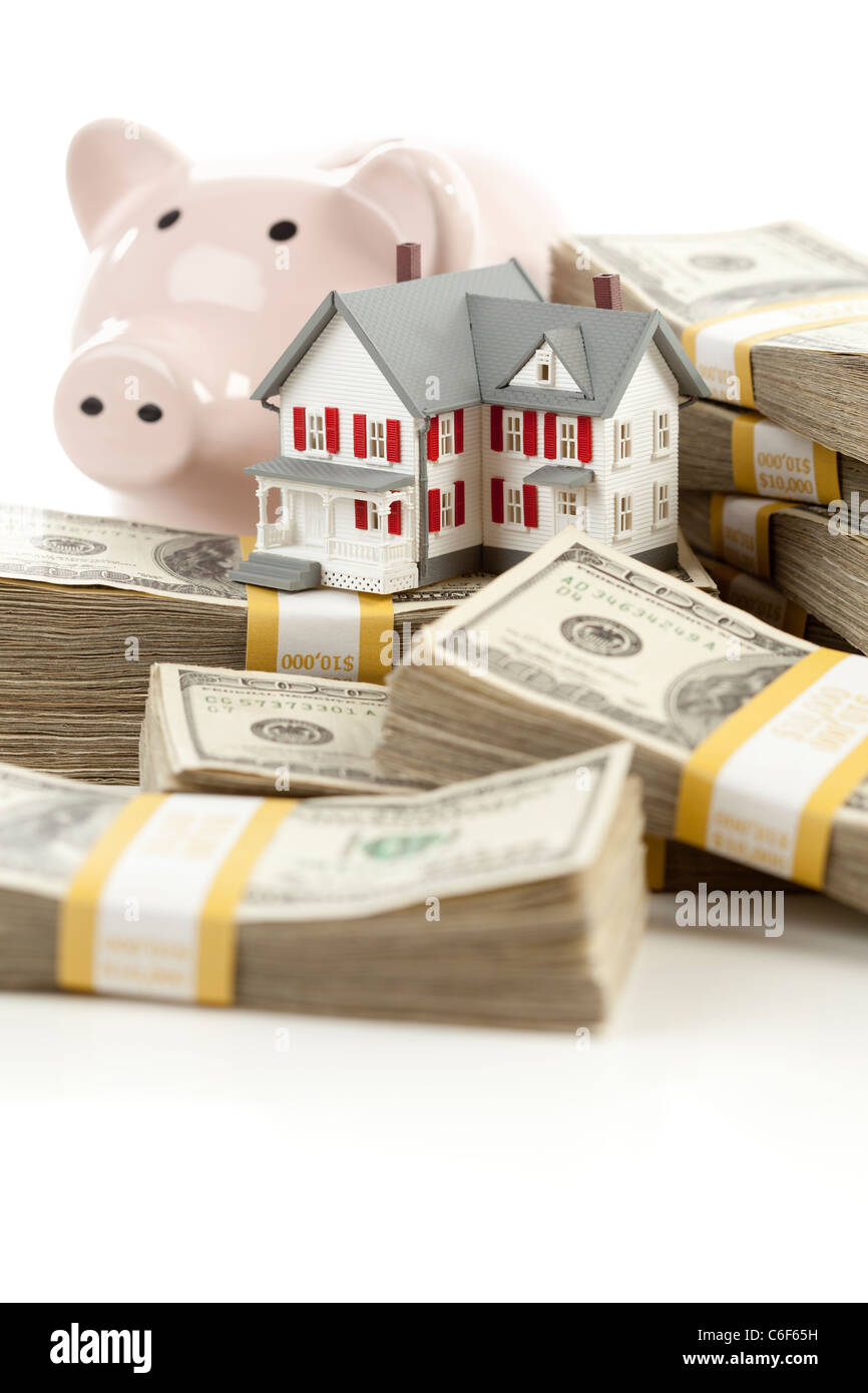 Petite maison et Tirelire avec des piles de cent piastres isolé sur un fond blanc. Banque D'Images