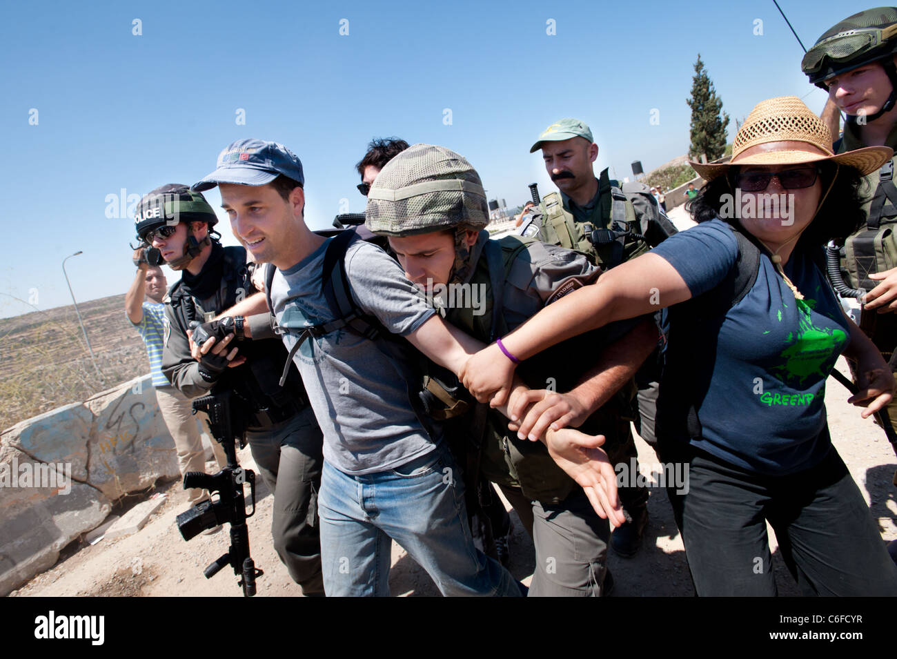 La police des frontières l'arrestation d'un militant israélien pour protester contre la barrière de séparation dans la ville cisjordanienne de Al-Walaja. Banque D'Images