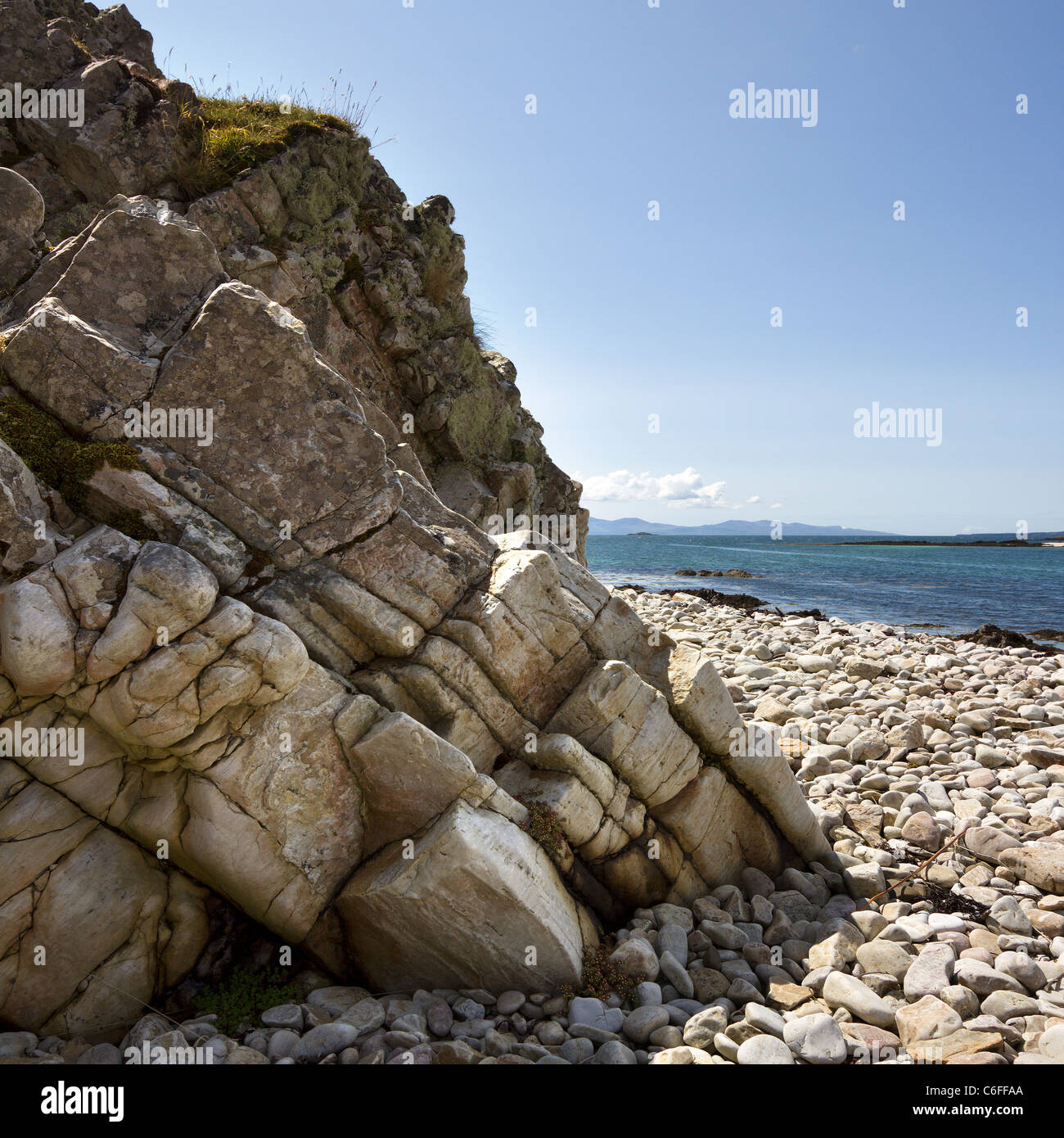 Des falaises rocheuses et de galets blancs avec Eishort et à l'île de Rum en distance, Ord, Isle of Skye, Scotland, UK Banque D'Images