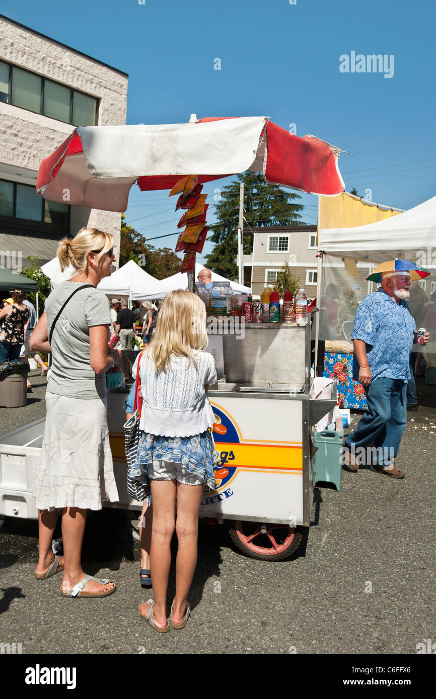 Mère aux cheveux flaxen & tween fille portant des jupes extraction envisager des hot-dogs à chariot mobile Edmonds farmers market Washington Banque D'Images