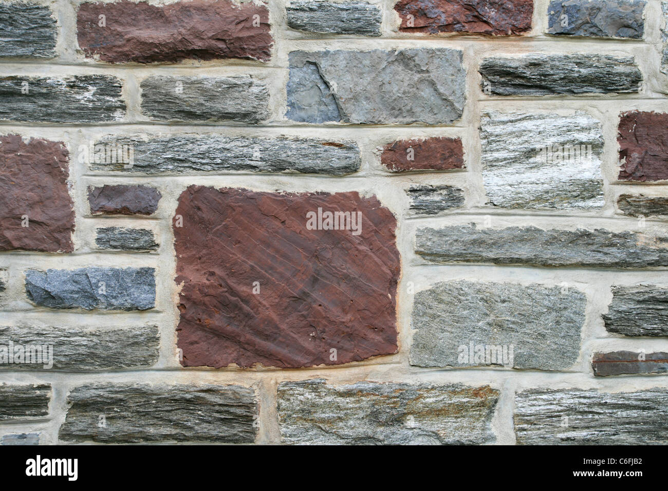 Détail du mur de pierre de grès rouge et gris avec des schistes wissahickon pâtés Banque D'Images
