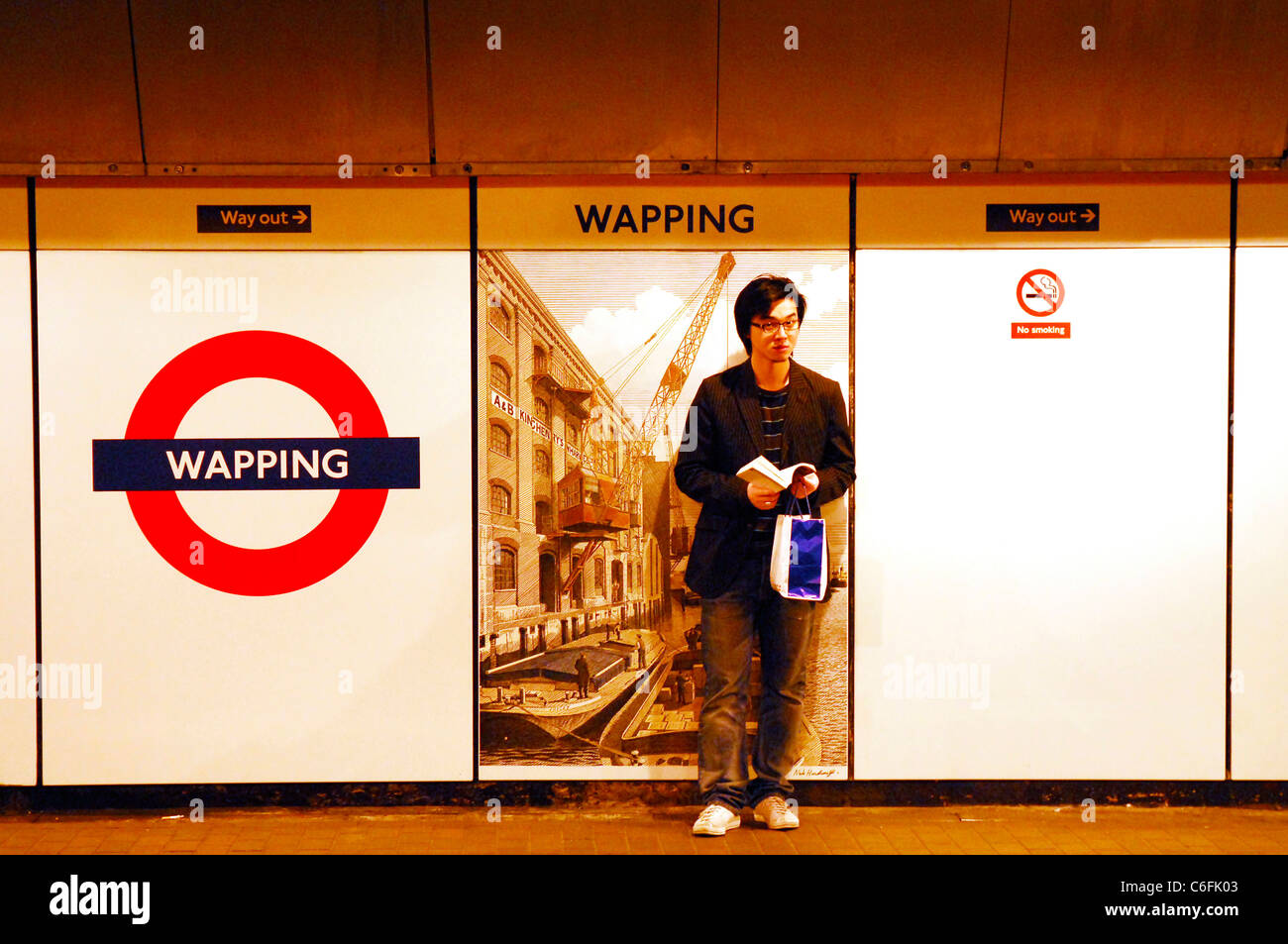 En attendant le métro, station de métro Wapping, London, E1 en 2004 Banque D'Images