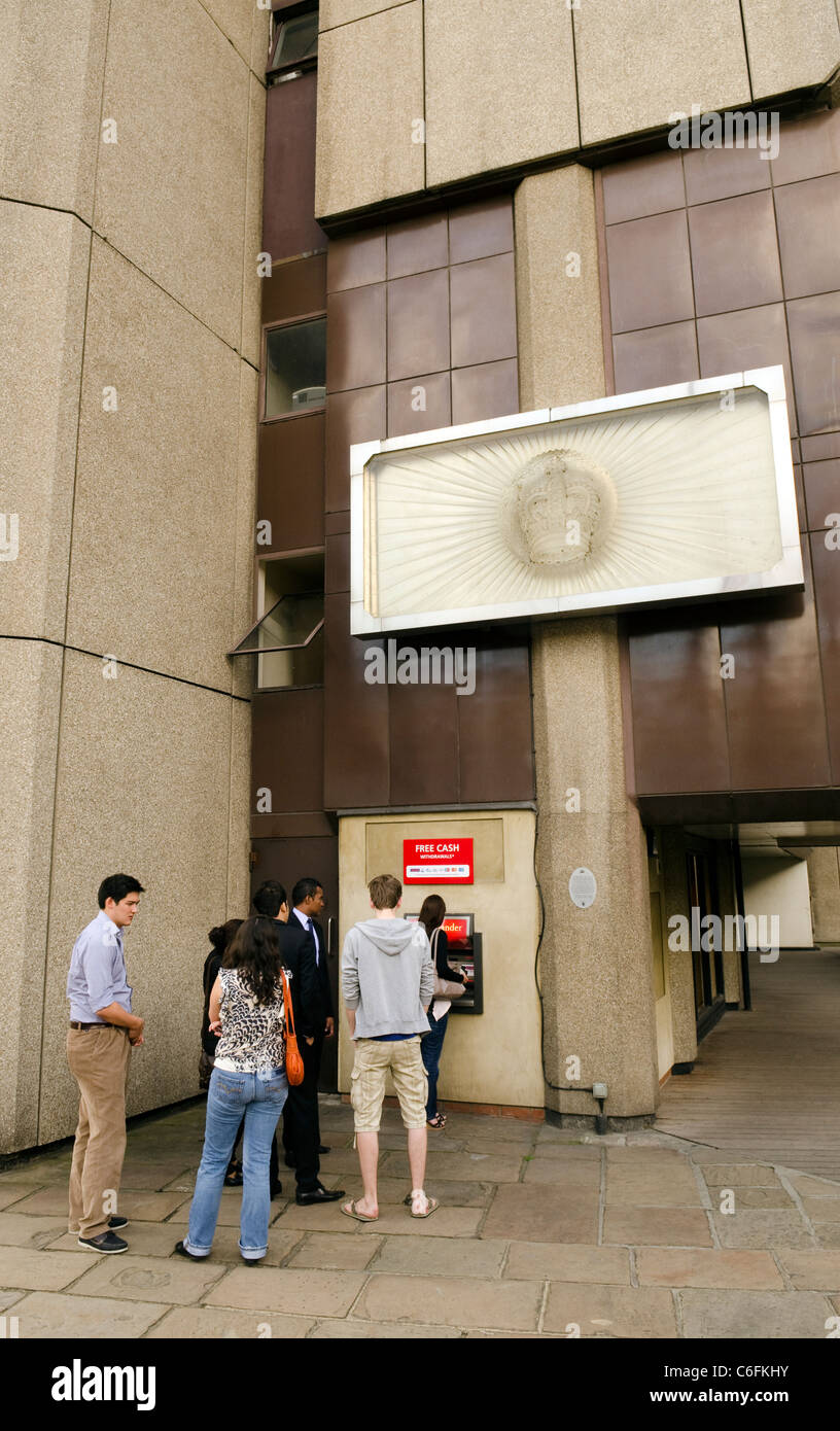 File d'attente de personnes de retirer de l'argent d'un distributeur à St Katharine's dock de Londres. Banque D'Images