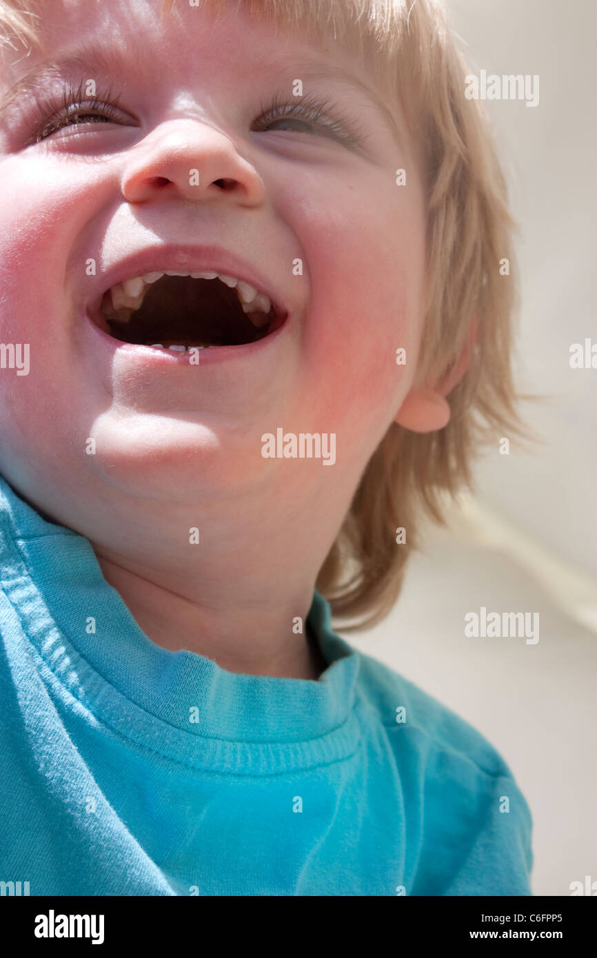Heureux enfant rire naturellement à l'extérieur au soleil Banque D'Images
