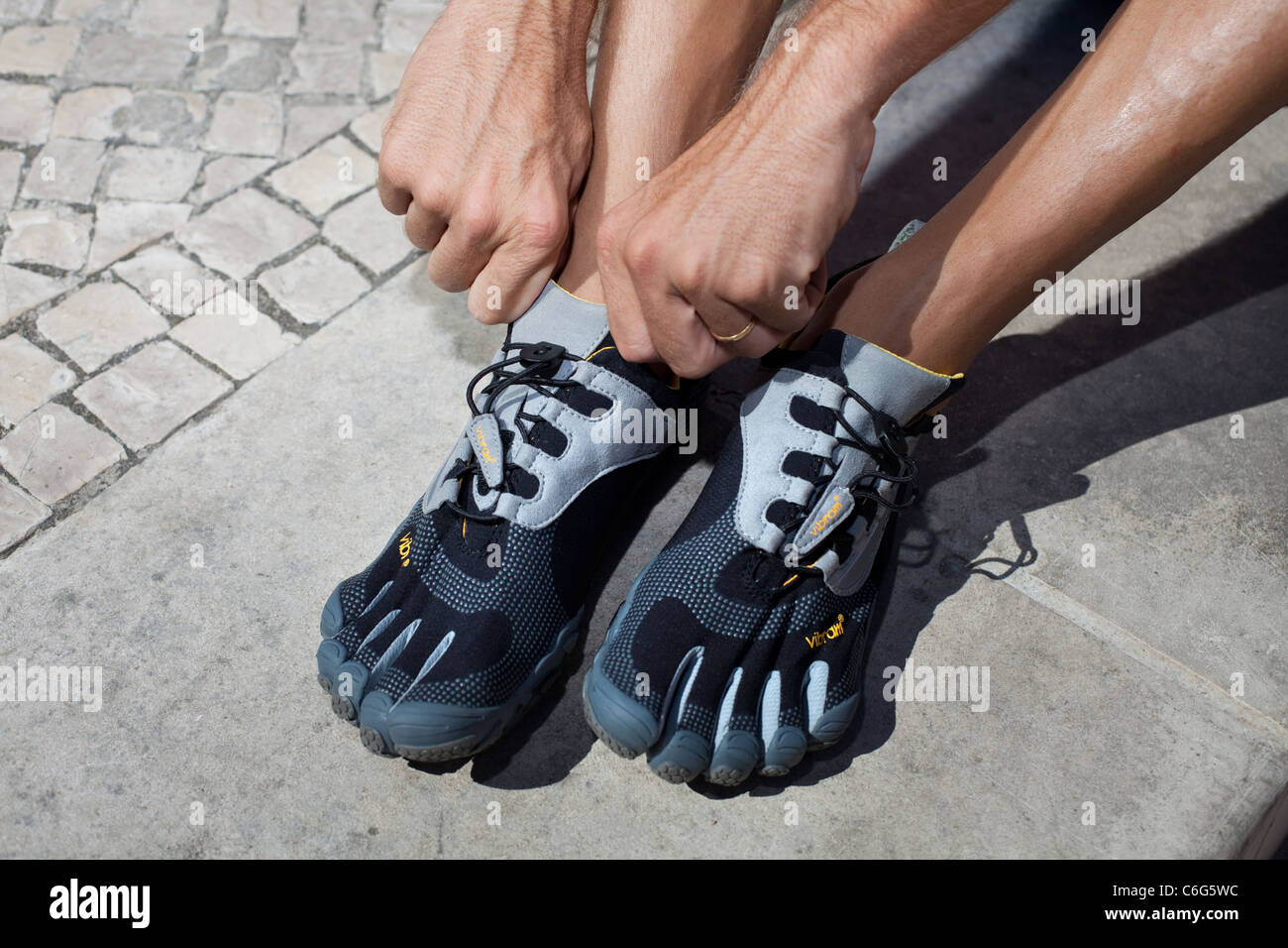 Man putting on vibram fivefingers chaussures. Banque D'Images