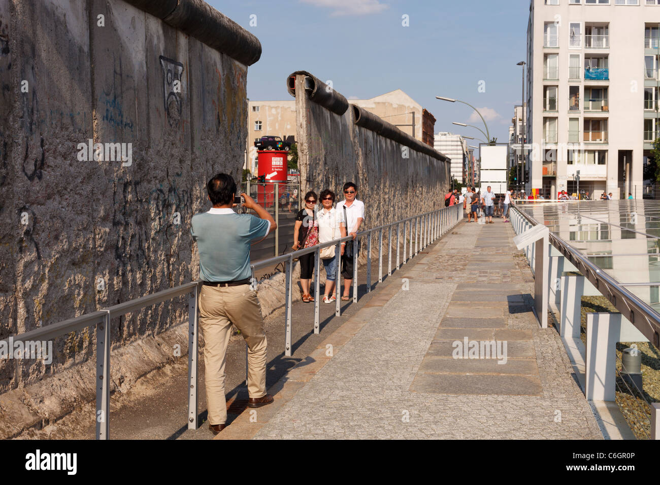 Les touristes de prendre une photo à un vestige du Mur de Berlin sur Niederkirchnerstrasse. Banque D'Images