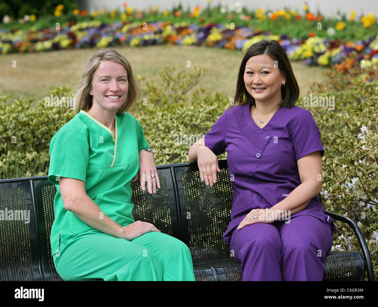 Deux infirmières de poser dans un jardin de l'hôpital. Banque D'Images