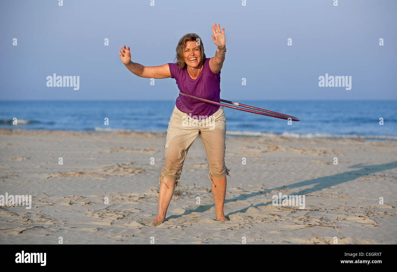 Une femme n'a le hula hoop sur la plage sur Sullivan's Island, Caroline du Sud. Banque D'Images