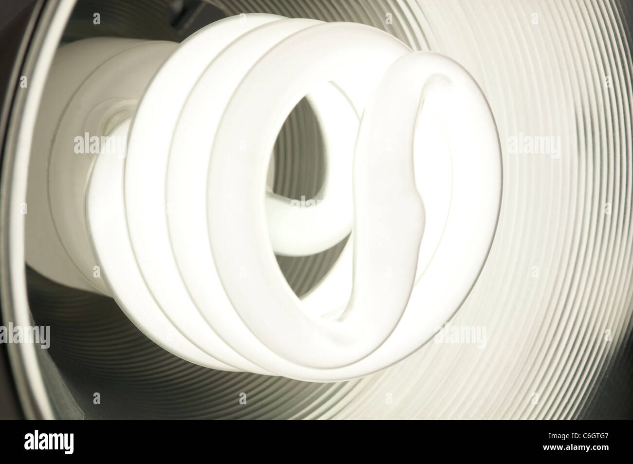 Ampoule fluorescente compacte à économie d'énergie à l'intérieur d'un rougeoyant plat rond en métal Banque D'Images