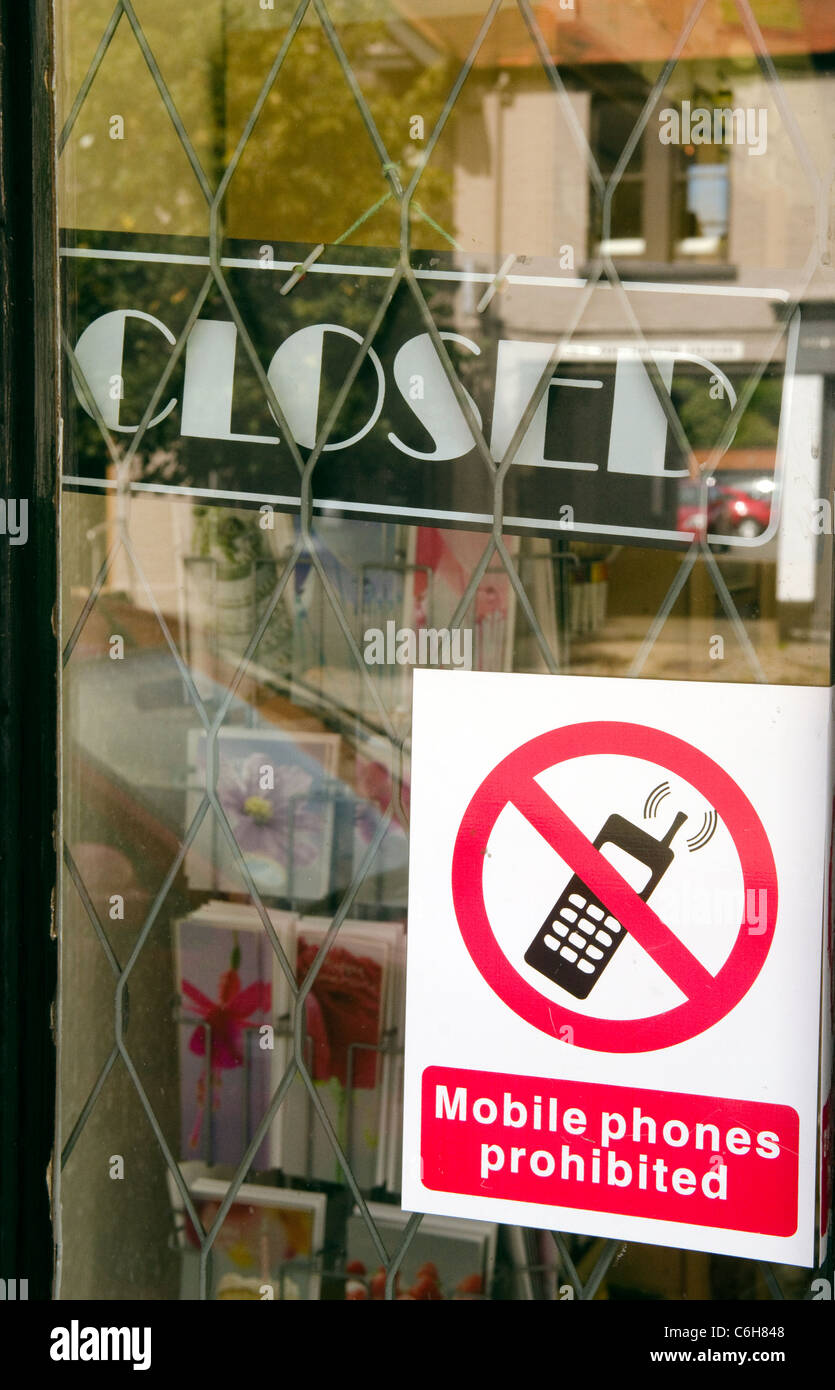 Shop enseigne de porte : ouverte et fermée et un signe interdit les téléphones portables dans des locaux commerciaux à Beaconsfield Bucks UK Banque D'Images