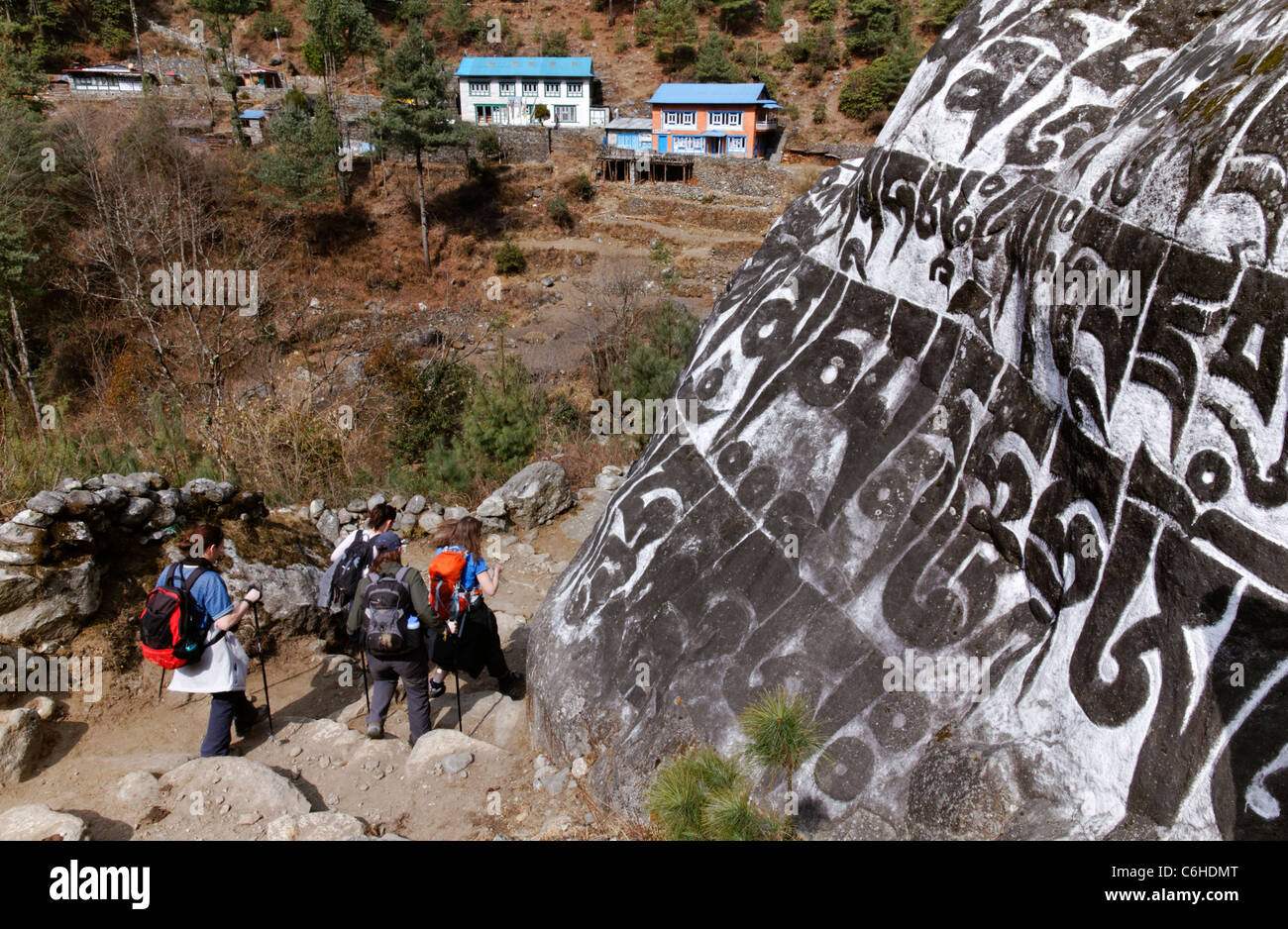 Les randonneurs en passant devant une mani sculpté pierre dans la région de l'Everest, au Népal Banque D'Images