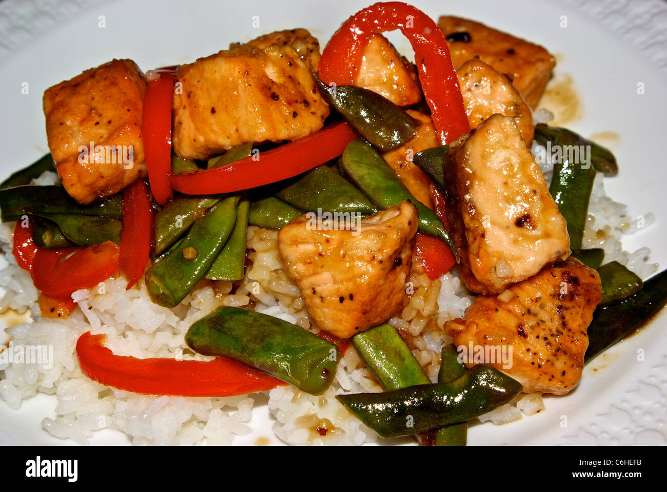 Morceaux de saumon sauté haricots verts poivrons rouges riz blanc vapeur Banque D'Images