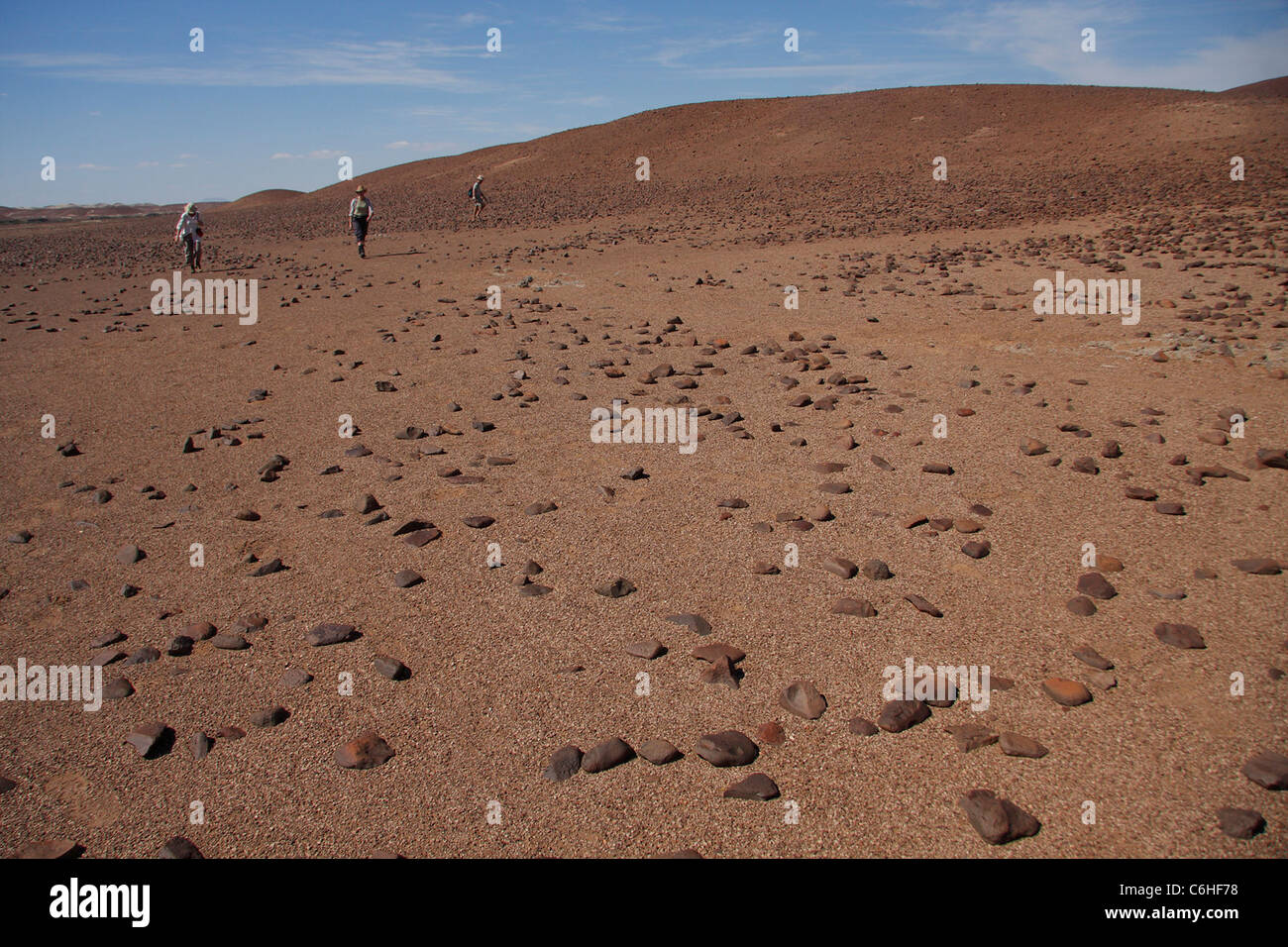Les Randonneurs marchant dans paysage désert pierreux Banque D'Images