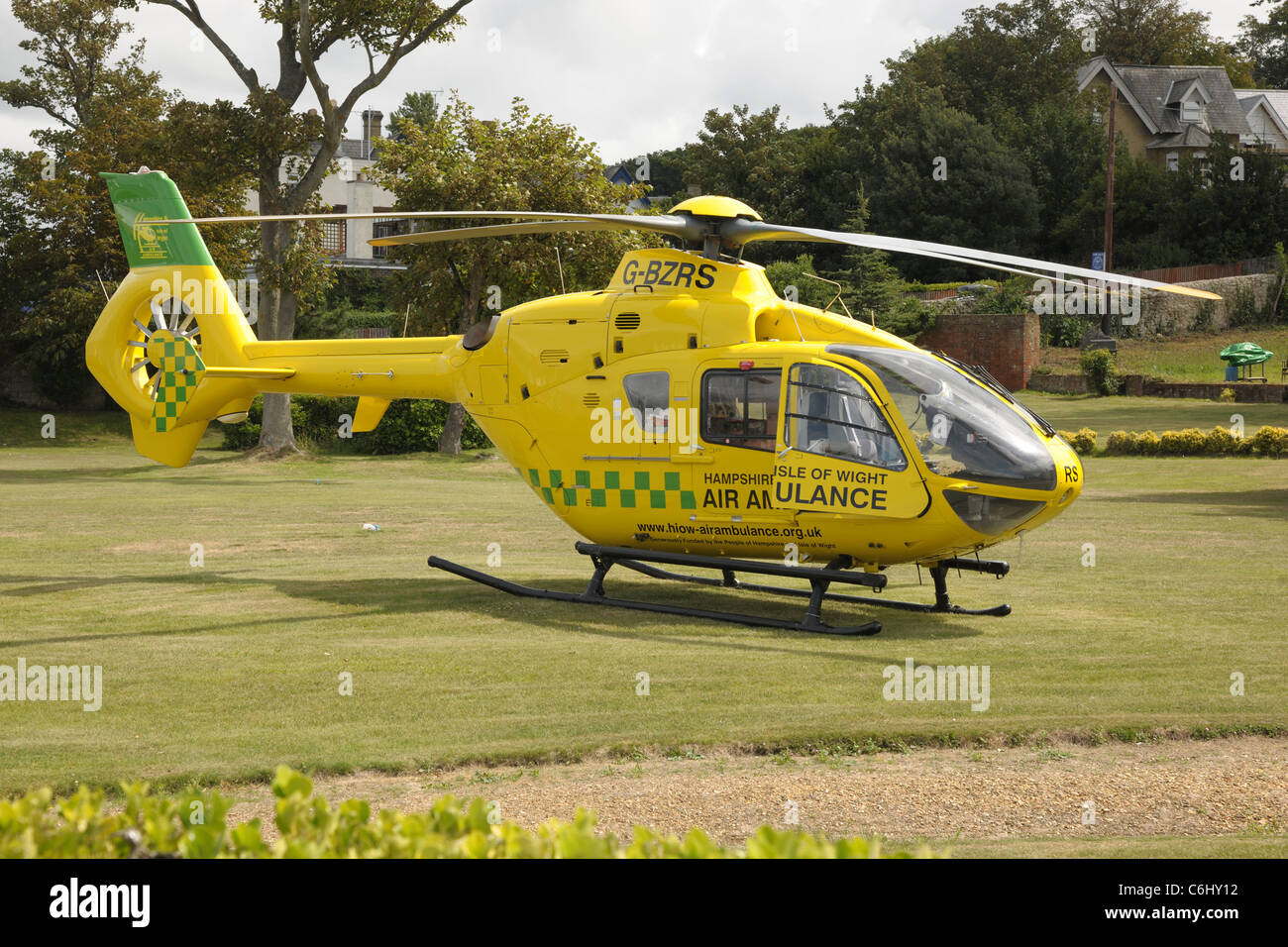 Hampshire & Isle Of Wight Eurocopter EC-135 air ambulance G-BZRS suite à un contrôle de l'atterrissage sur une pelouse. Banque D'Images