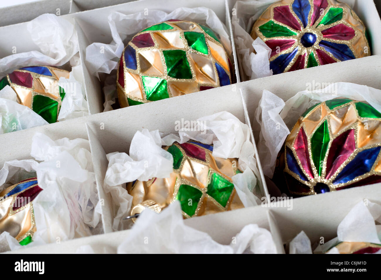 Décorations de Noël dans une boîte. Boules de verre soufflé à la main dans des couleurs rouge bleu vert et or Banque D'Images
