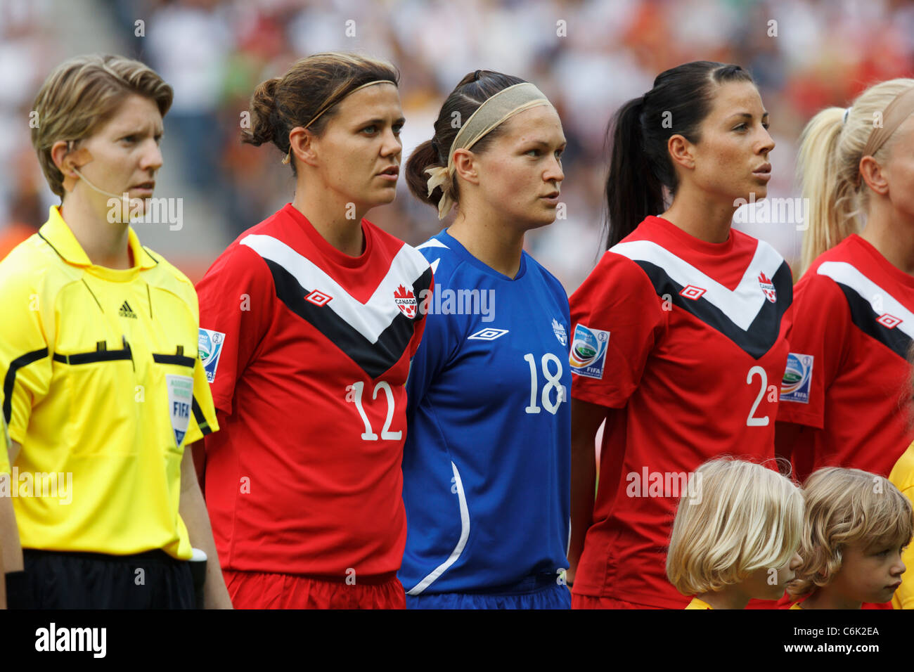 Les joueuses canadiennes Christine Sinclair (12 ans), Erin McLeod (18 ans) et Emily Zurrer (2 ans) chantent l'hymne national avant un match de la Coupe du monde féminine contre l'Allemagne. Banque D'Images