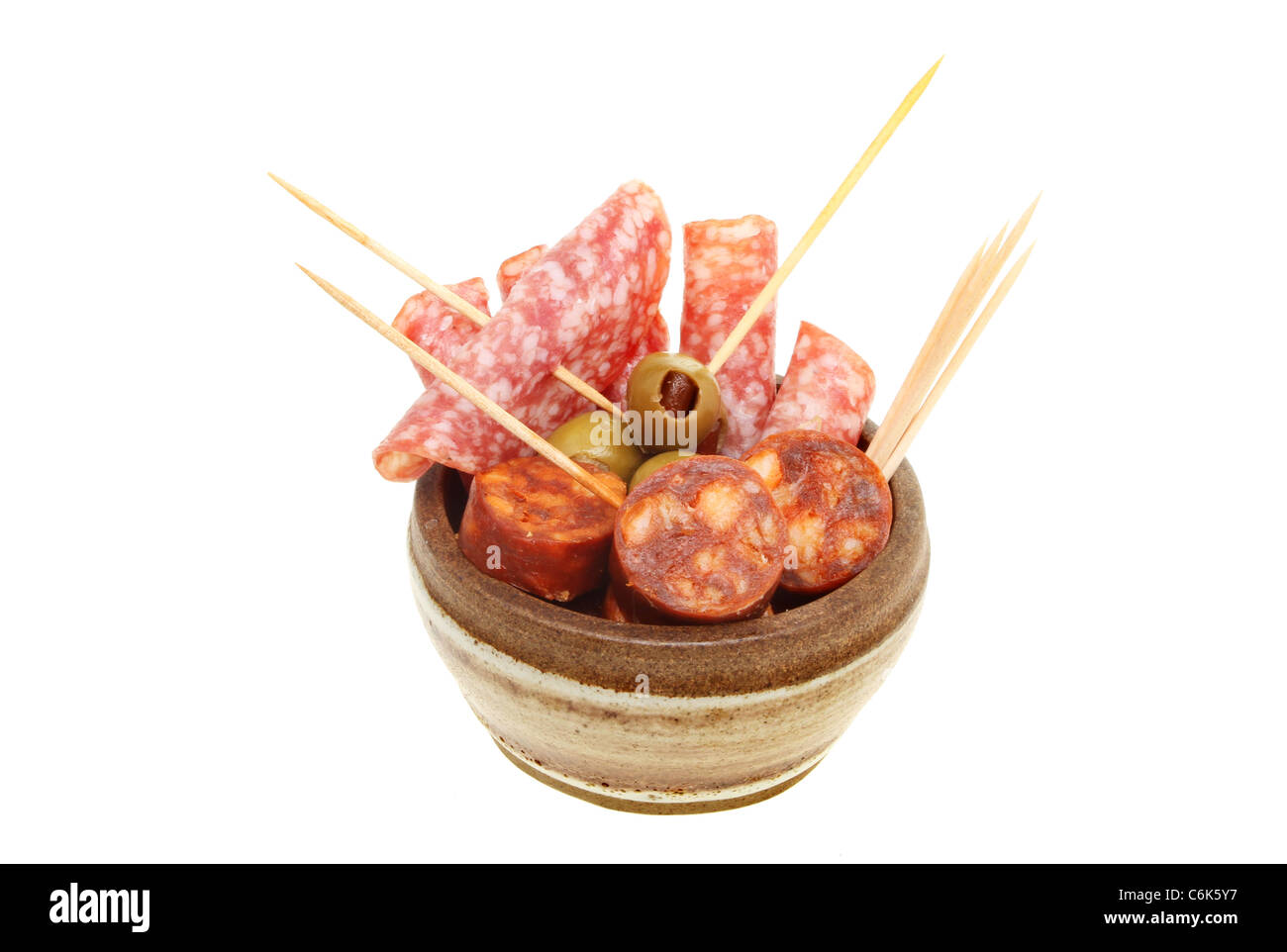 Des tapas dans un bol, salami, saucisson chorizo et les olives dans un bol avec des bâtons à cocktail Banque D'Images