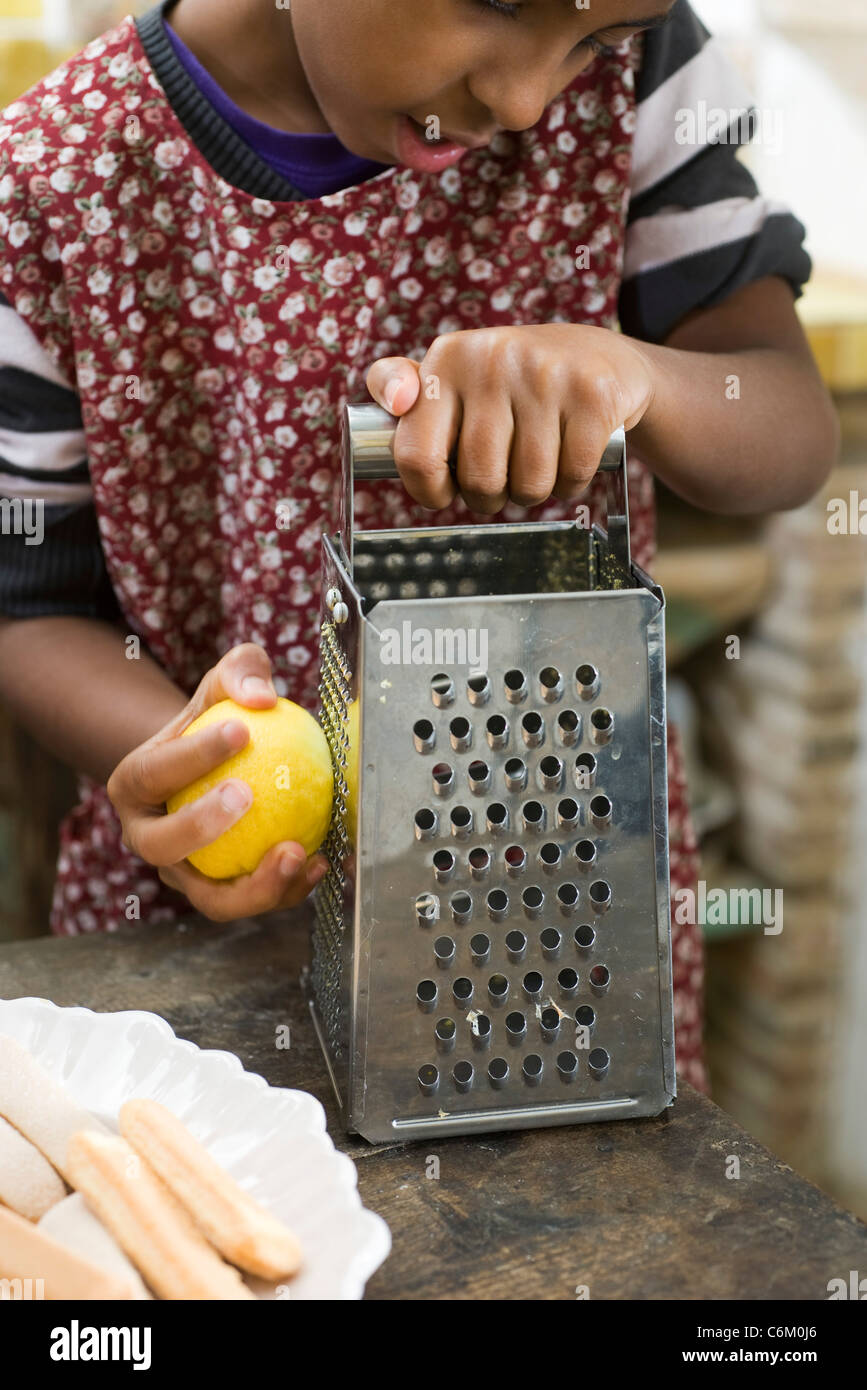 Zesting fille un citron Banque D'Images