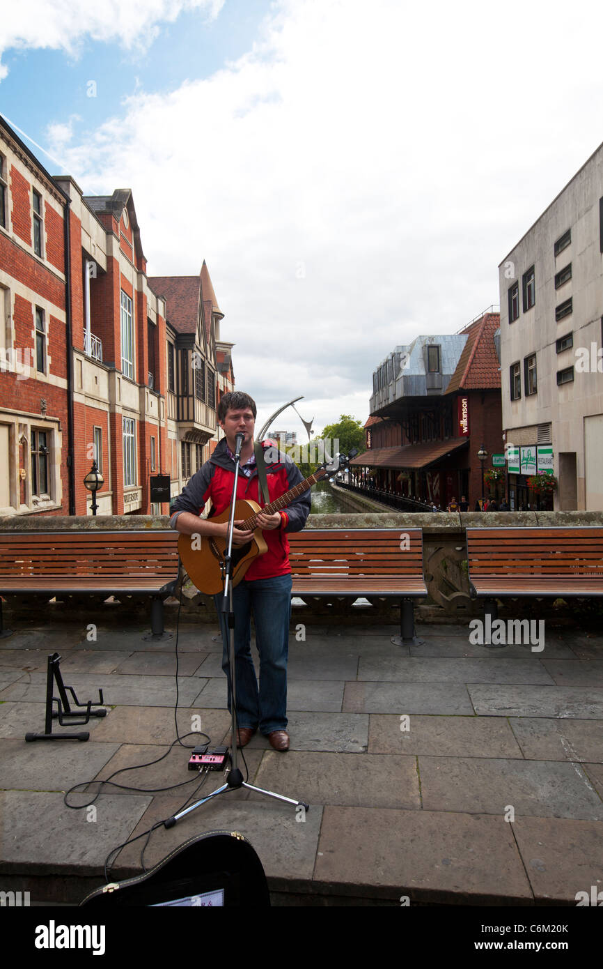 La ville de Lincoln, Lincolnshire musicien ambulant qui joue de la guitare sur la rue avec rivière witham derrière Banque D'Images