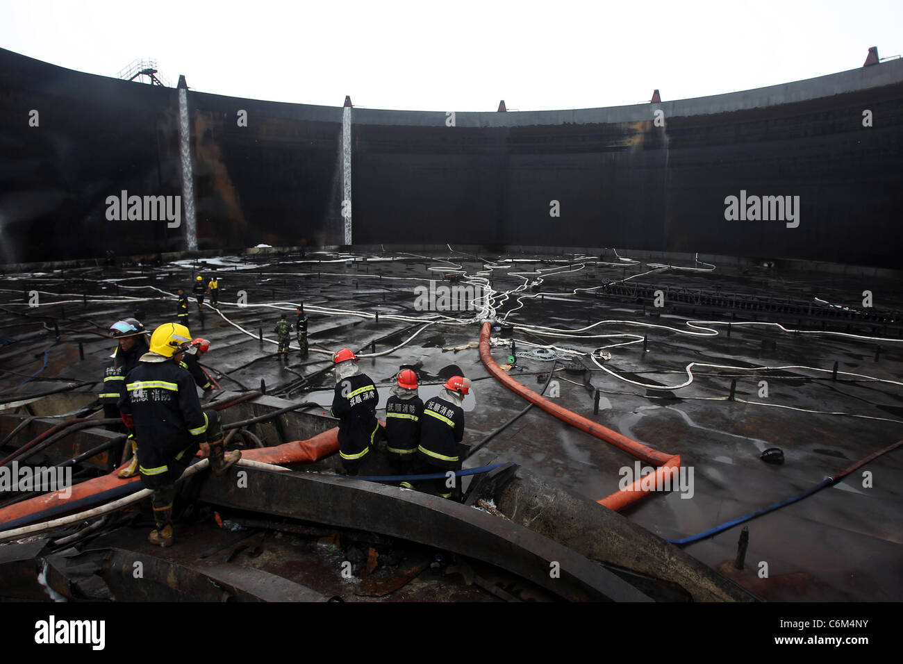 Aider les pompiers de souffle d'huile nettoyage pompiers à Dalian, Chine démarrer l'effort de nettoyage après avoir aidé à mettre une rage Banque D'Images