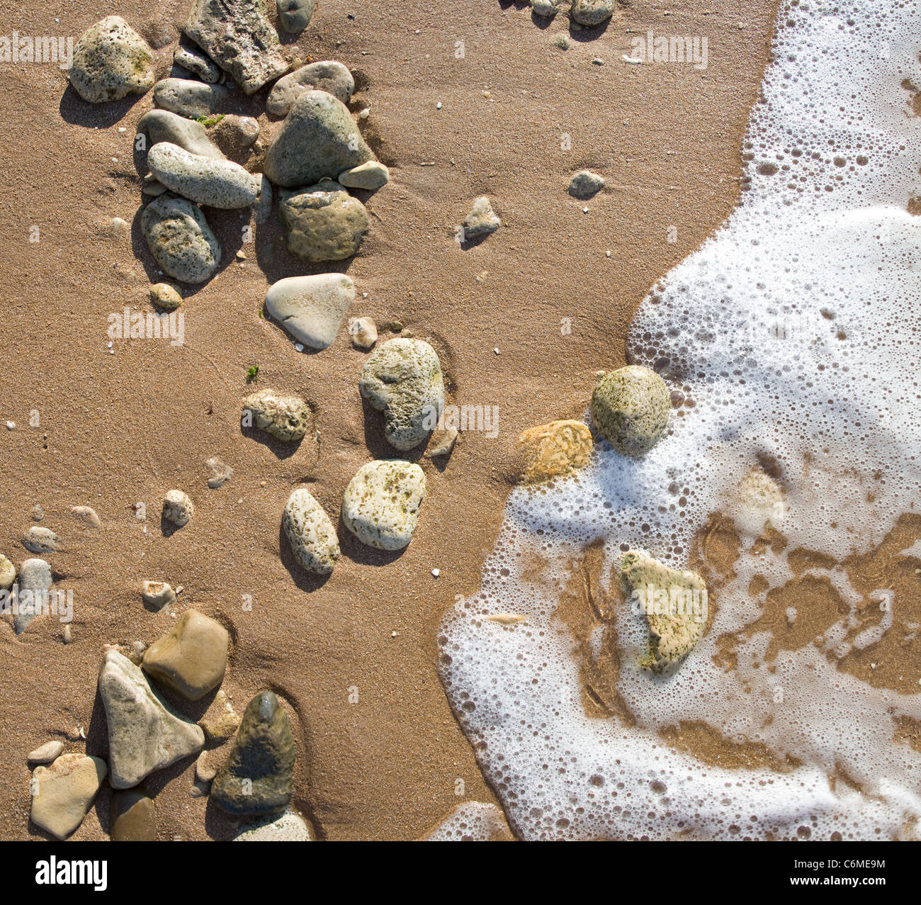 Sur une plage de galets de la mer dans les vagues. Banque D'Images
