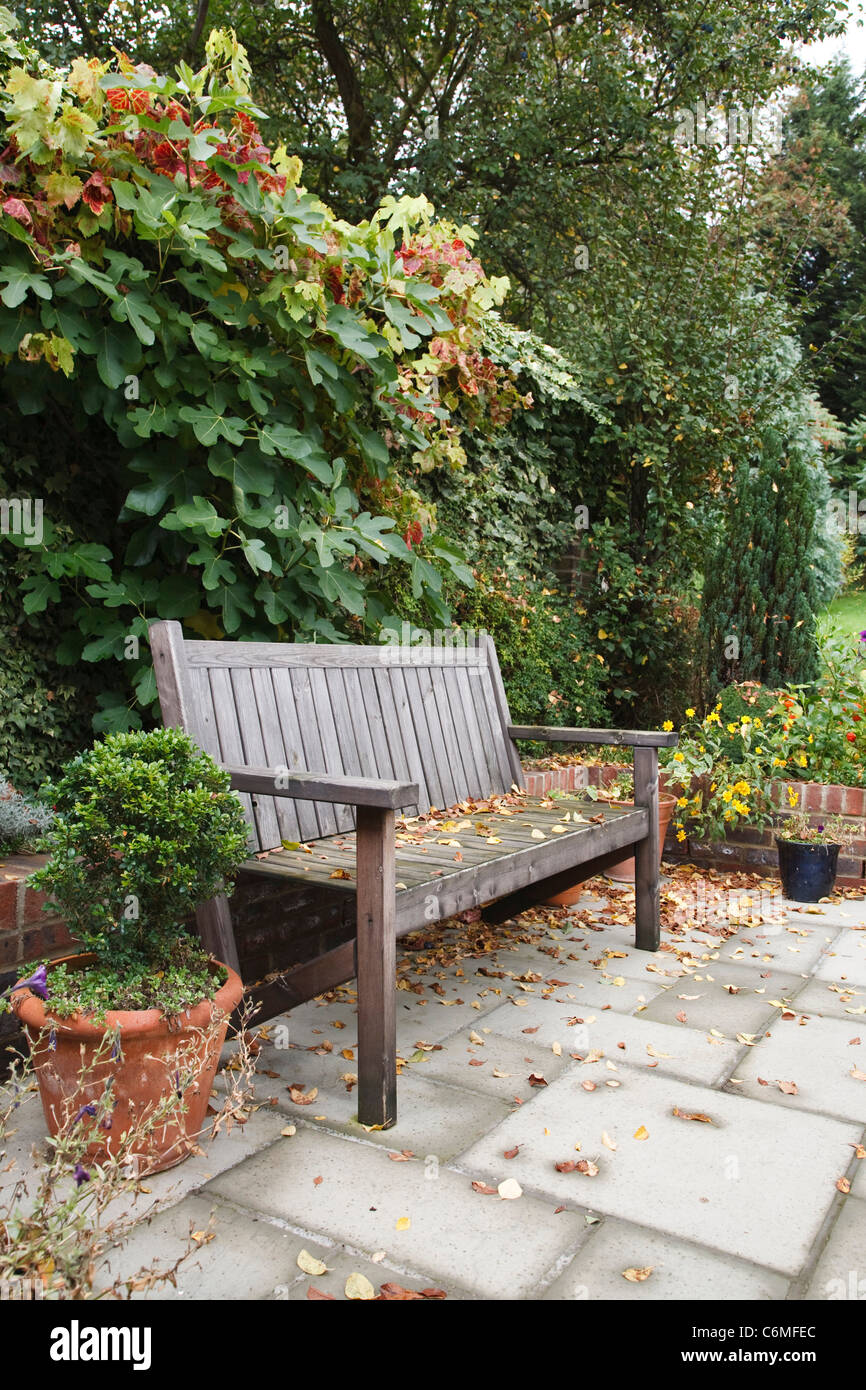 Cour-jardin informel à l'automne, avec un banc en bois et pavage  traditionnel patio Photo Stock - Alamy