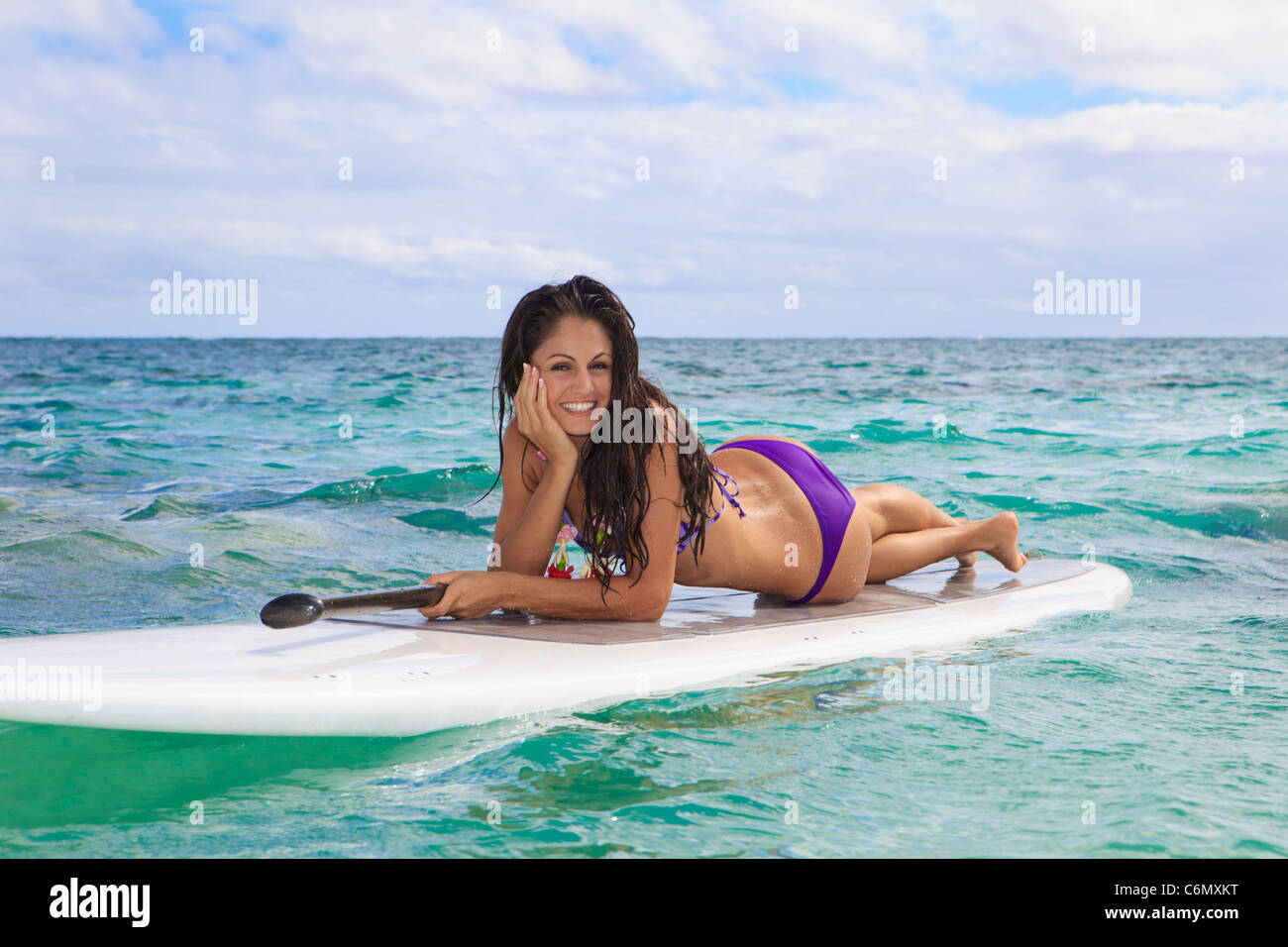 Belle brune en bikini sur son stand up paddle board à Hawaï Banque D'Images