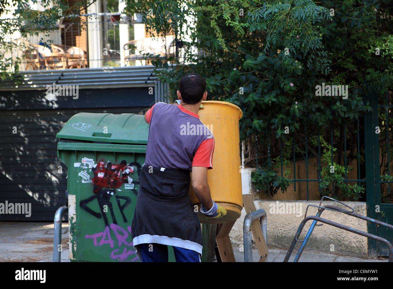 Balayeuse à Athènes en vidant une trémie dans le bord de la route les poubelles Banque D'Images