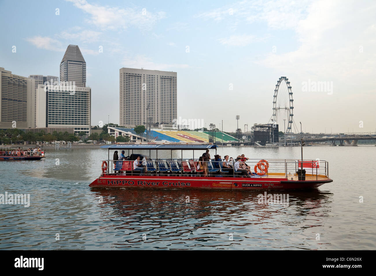 Un bateau de tourisme traverse marina bay avec le flyer en arrière-plan, l'Asie Singapour Banque D'Images