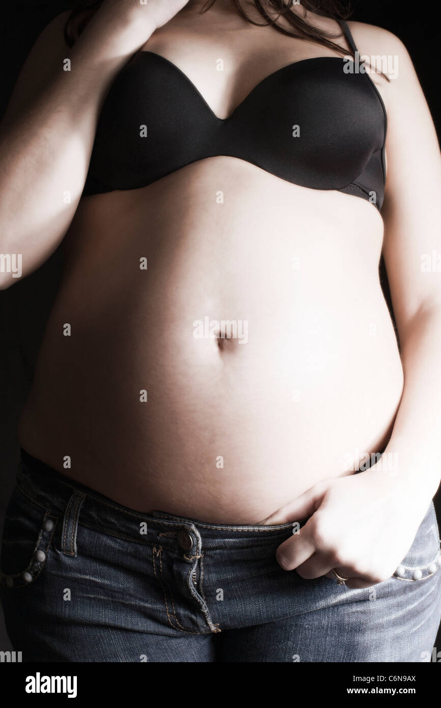 Gros Ventre femme enceinte en jean et soutien-gorge noir sur fond noir  Photo Stock - Alamy
