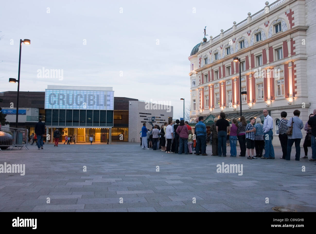 File de gens qui attendaient dehors théâtre Crucible et Lyceum Theatre au crépuscule, Tudor Square, le centre-ville de Sheffield, UK Banque D'Images
