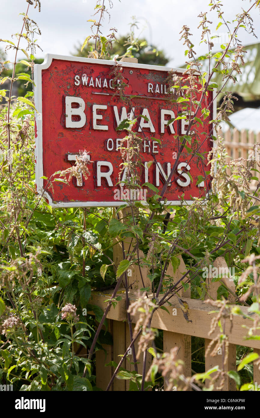 Un vieux "Méfiez-vous des Trains' en regard de la gare de château de Corfe, Dorset. Banque D'Images