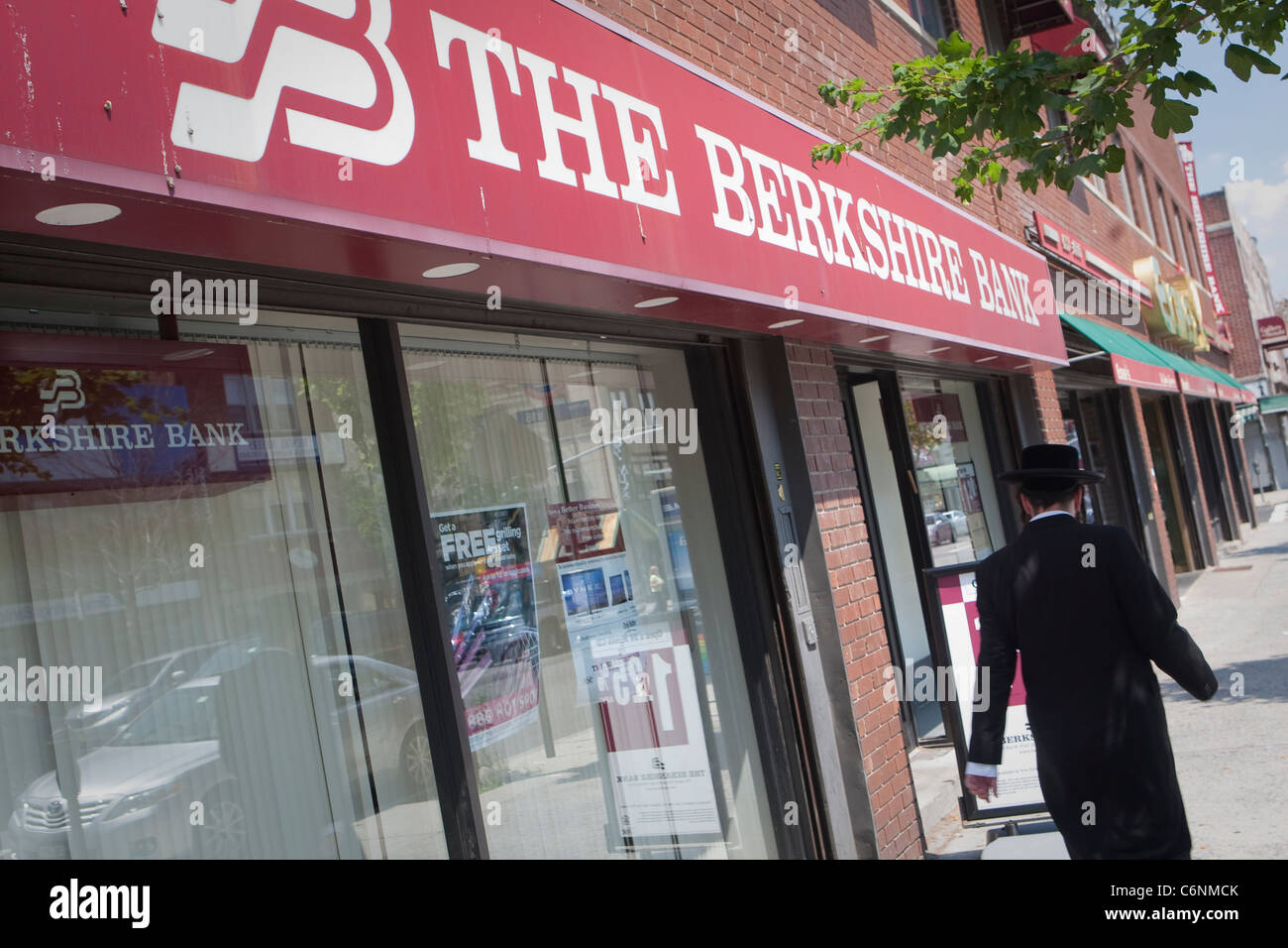 Un des hommes juifs hassidiques promenades par une succursale bancaire de la Berkshire dans le Borough Park de New York City Banque D'Images