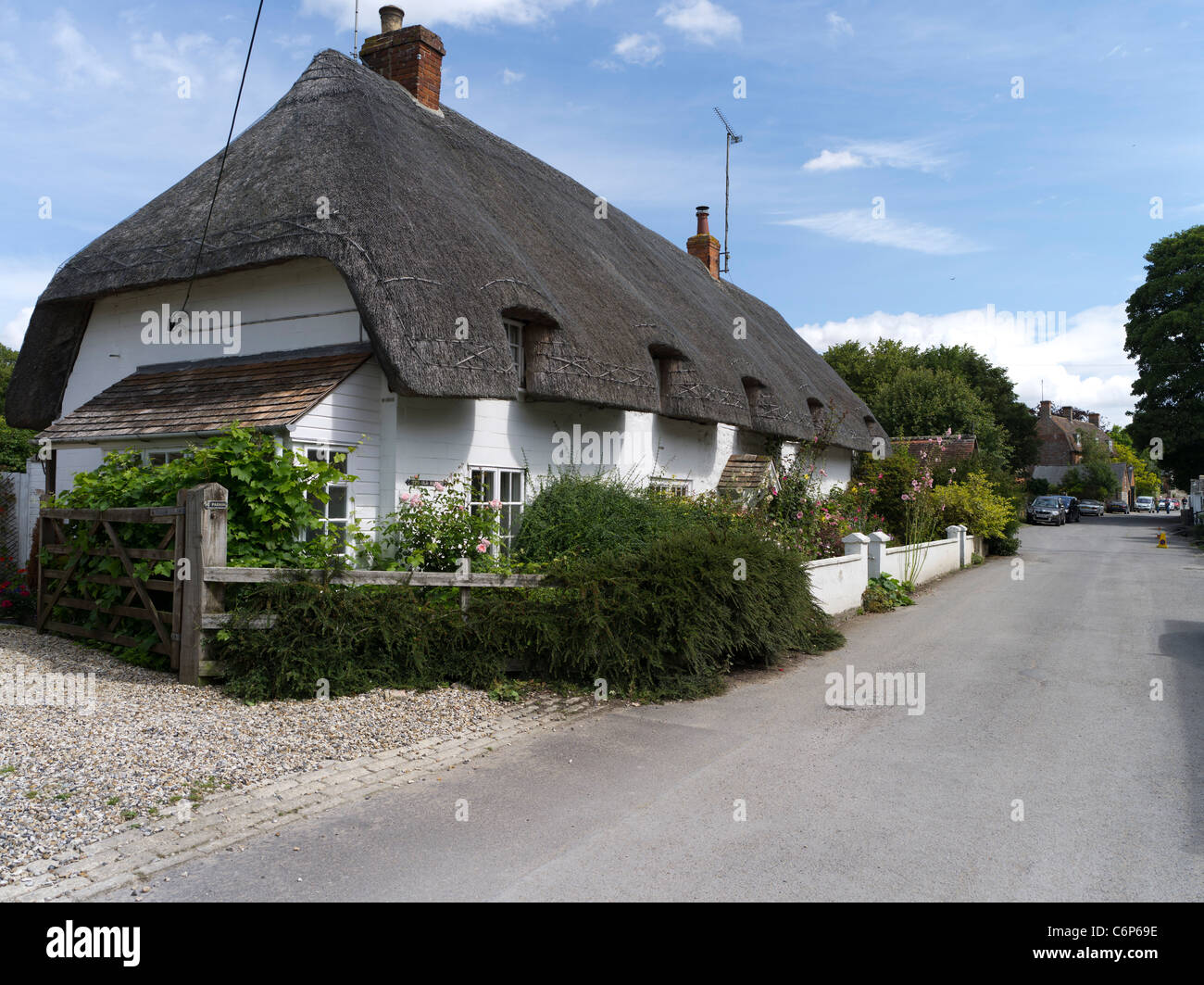 dh AVEBURY WILTSHIRE chemin de village anglais chaume cottage angleterre thatched le toit abrite une allée idyllique de campagne d'été au royaume-uni Banque D'Images