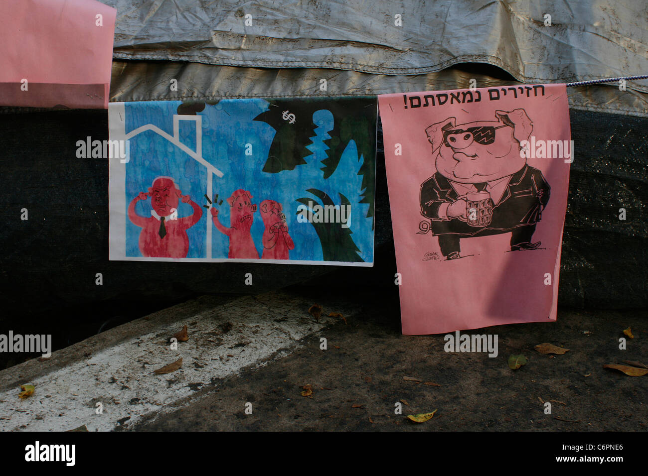 Affiches cynique contre l'inégalité sociale en Israël pendus de militants dans une ville de tentes à Tel Aviv, Israël. Banque D'Images