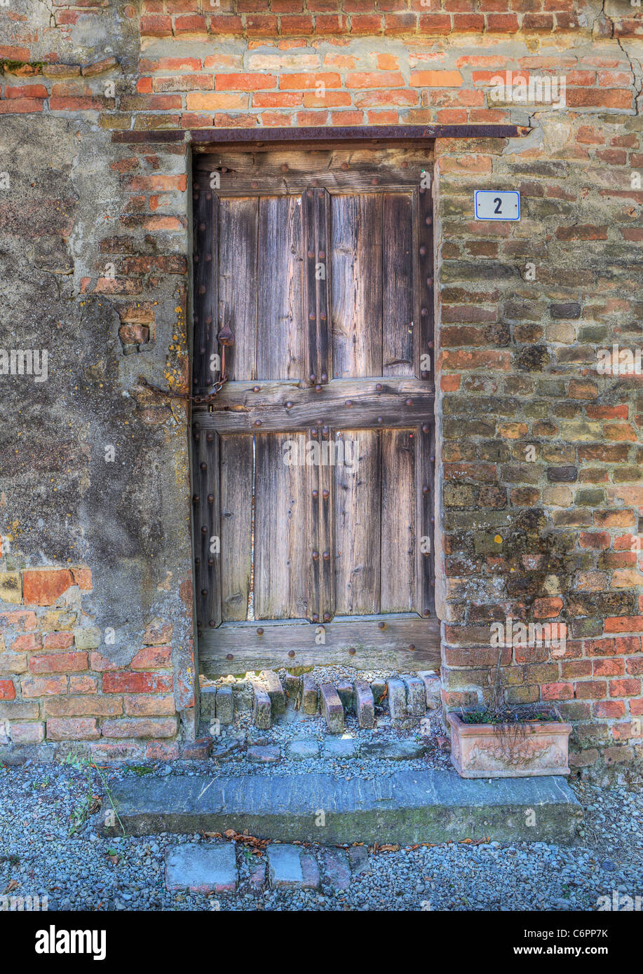 Image d'orientation verticale vintage porte en bois et mur de brique en Roddi - petite ville du Piémont, Italie du nord. Banque D'Images