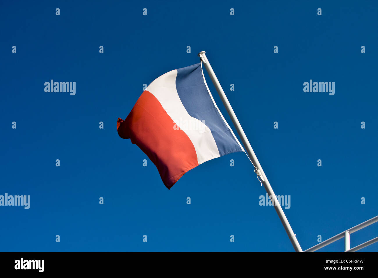 Drapeau français voler contre un ciel bleu Banque D'Images