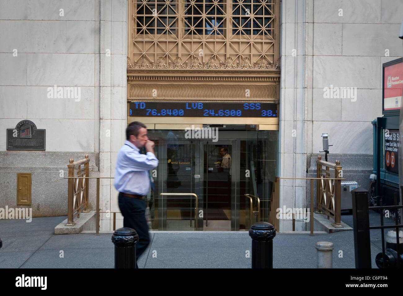 Un homme marche par les cours de la bourse à la Bourse de New York dans
