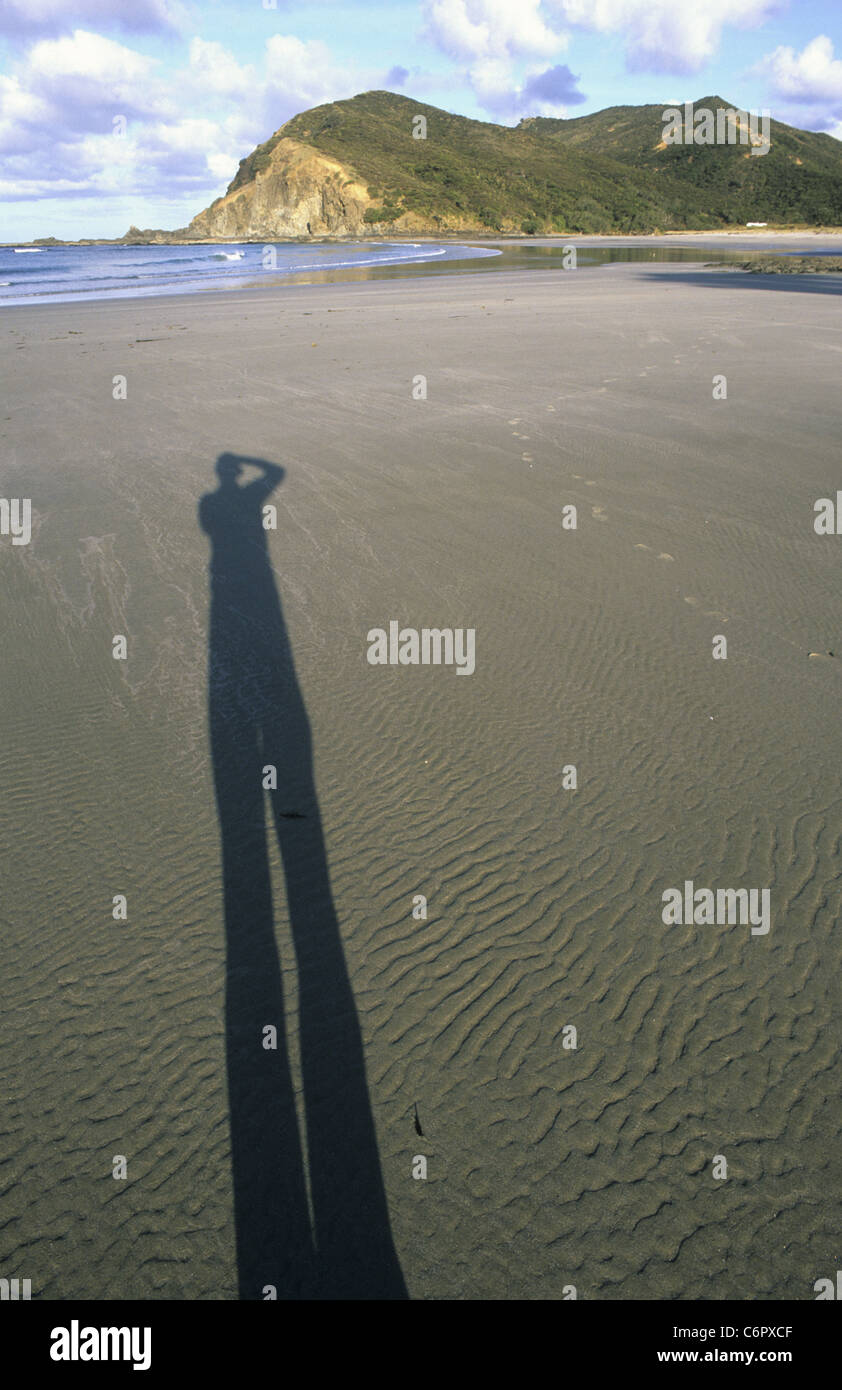 Ombre d'un homme prend une photo sur une plage en Nouvelle Zélande Banque D'Images