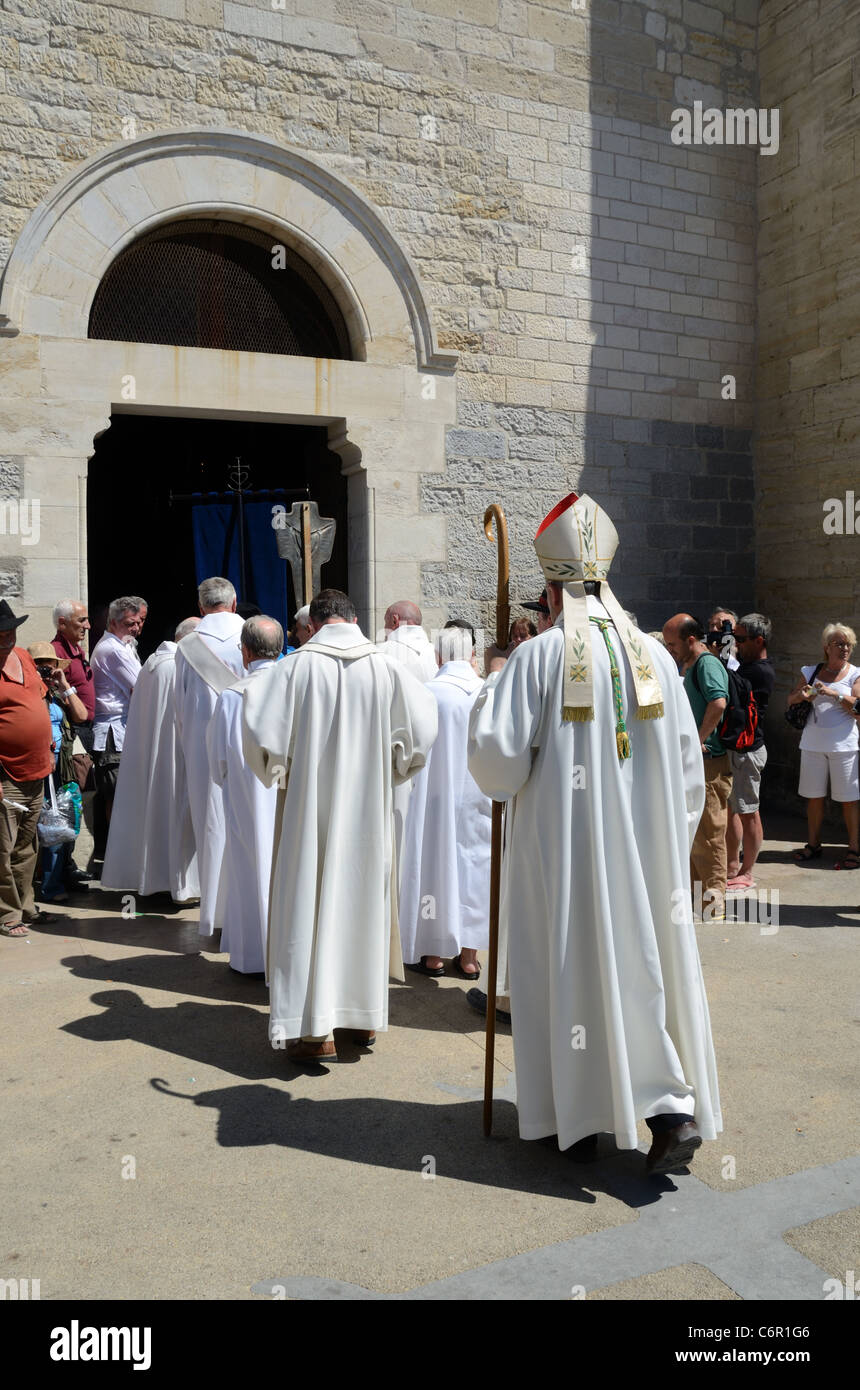 Clergé catholique portant des cassocks entrant dans l'église forte des les Saintes-Maries-de-la-Mer lors d'un festival tzigane Camargue Provence Banque D'Images