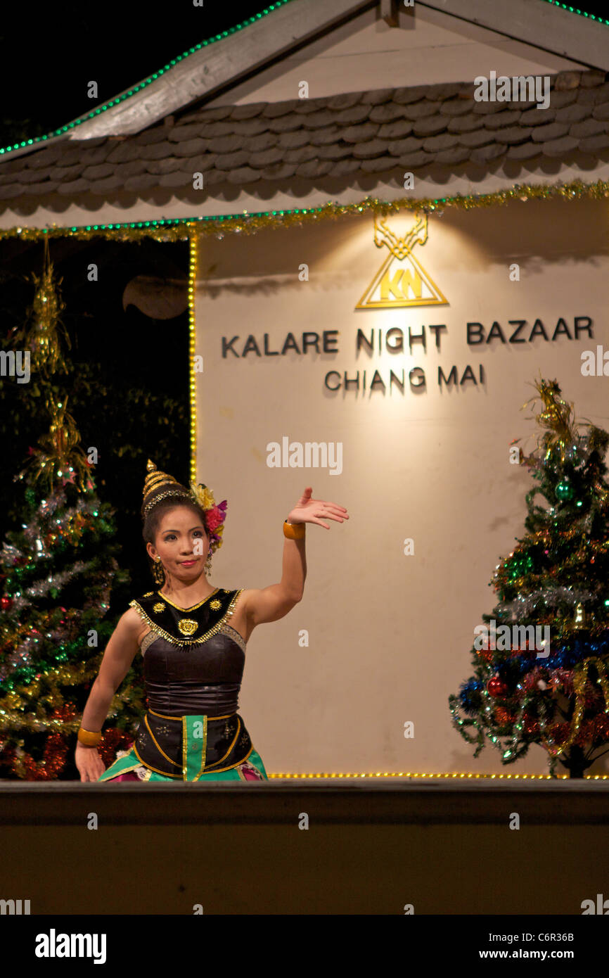 Une danseuse traditionnelle thaïlandaise en tenue traditionnelle danse avec des mouvements des mains expressives au Kalare night market Banque D'Images
