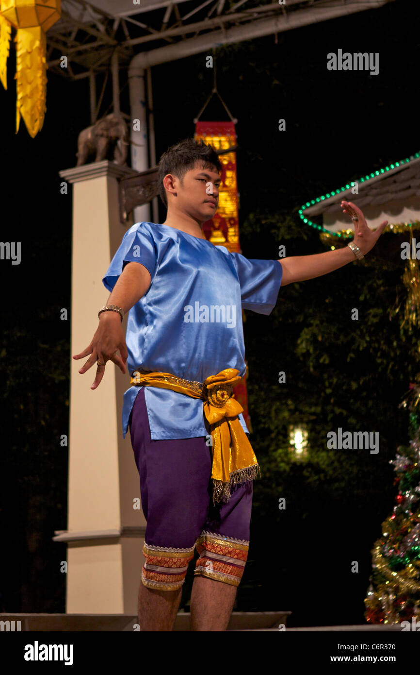 Un danseur traditionnel thaï en tenue traditionnelle danse avec des mouvements des mains expressives au Kalare night market Banque D'Images