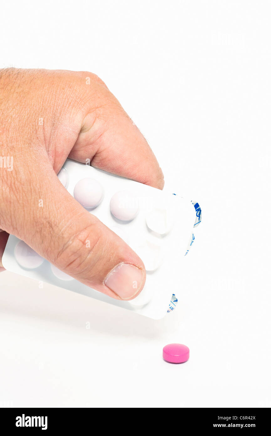 Une personne poussant une pilule rose sur un blister Banque D'Images