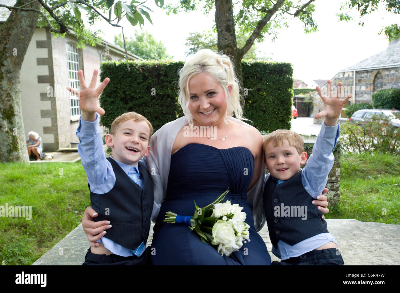 Matrone de l'honneur. Une jeune mère avec ses jumeaux âgés de 6 ans à un mariage de famille. Banque D'Images