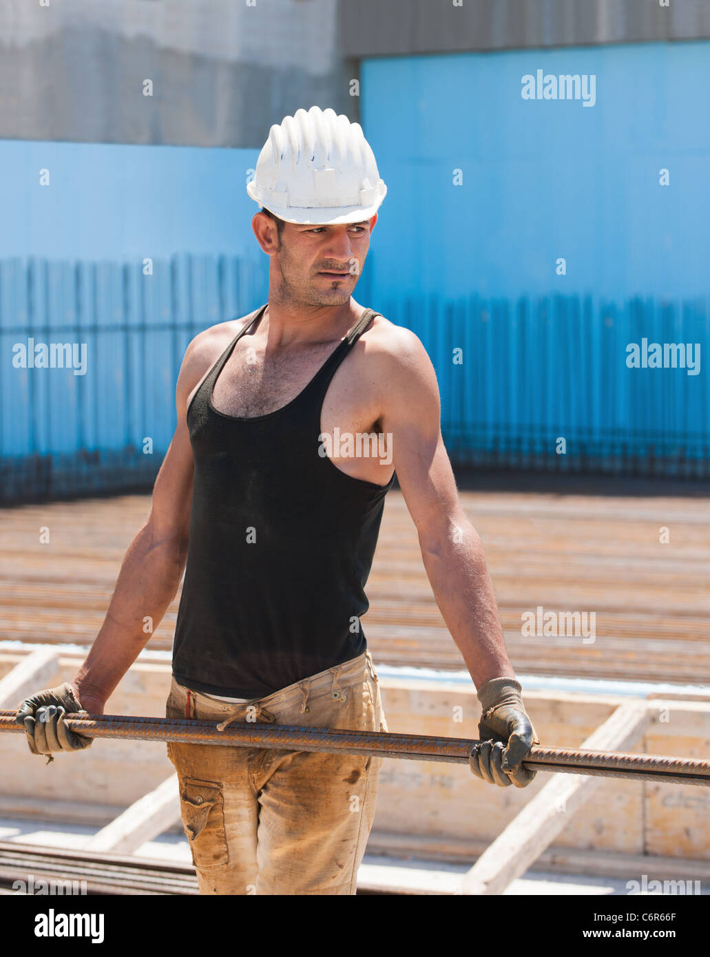 Construction Worker carrying barres d'acier de renfort Banque D'Images