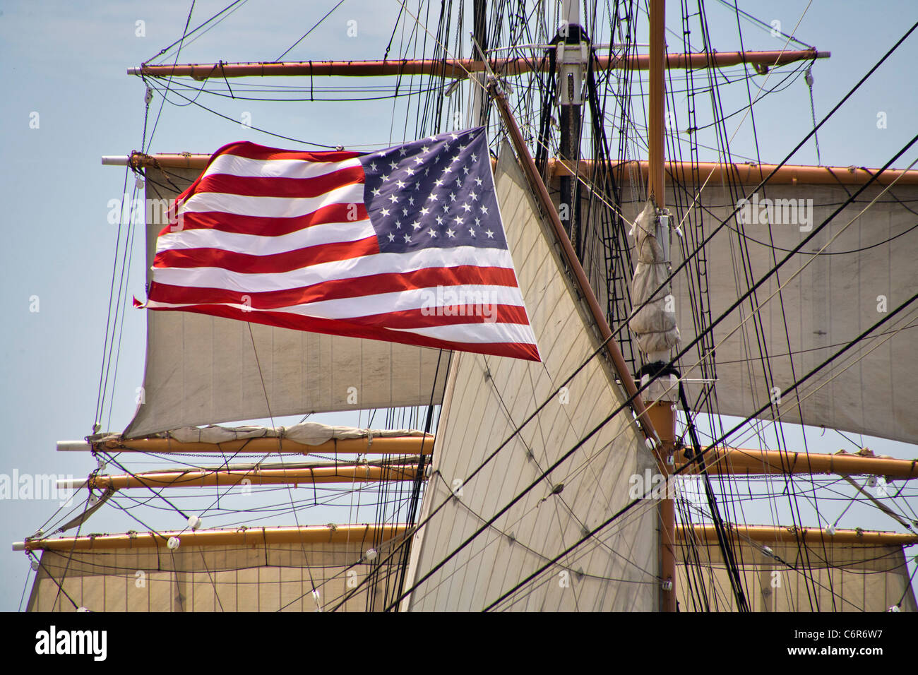 Un drapeau américain s'élève dans le vent sur le Windjammer voilier Star de l'Inde à la Musée maritime de San Diego. Banque D'Images