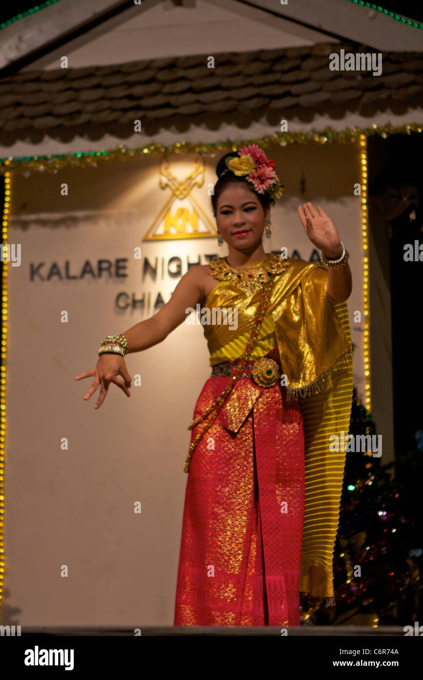 Une danseuse traditionnelle thaïlandaise en tenue traditionnelle danse avec des mouvements des mains expressives au Kalare night market Banque D'Images