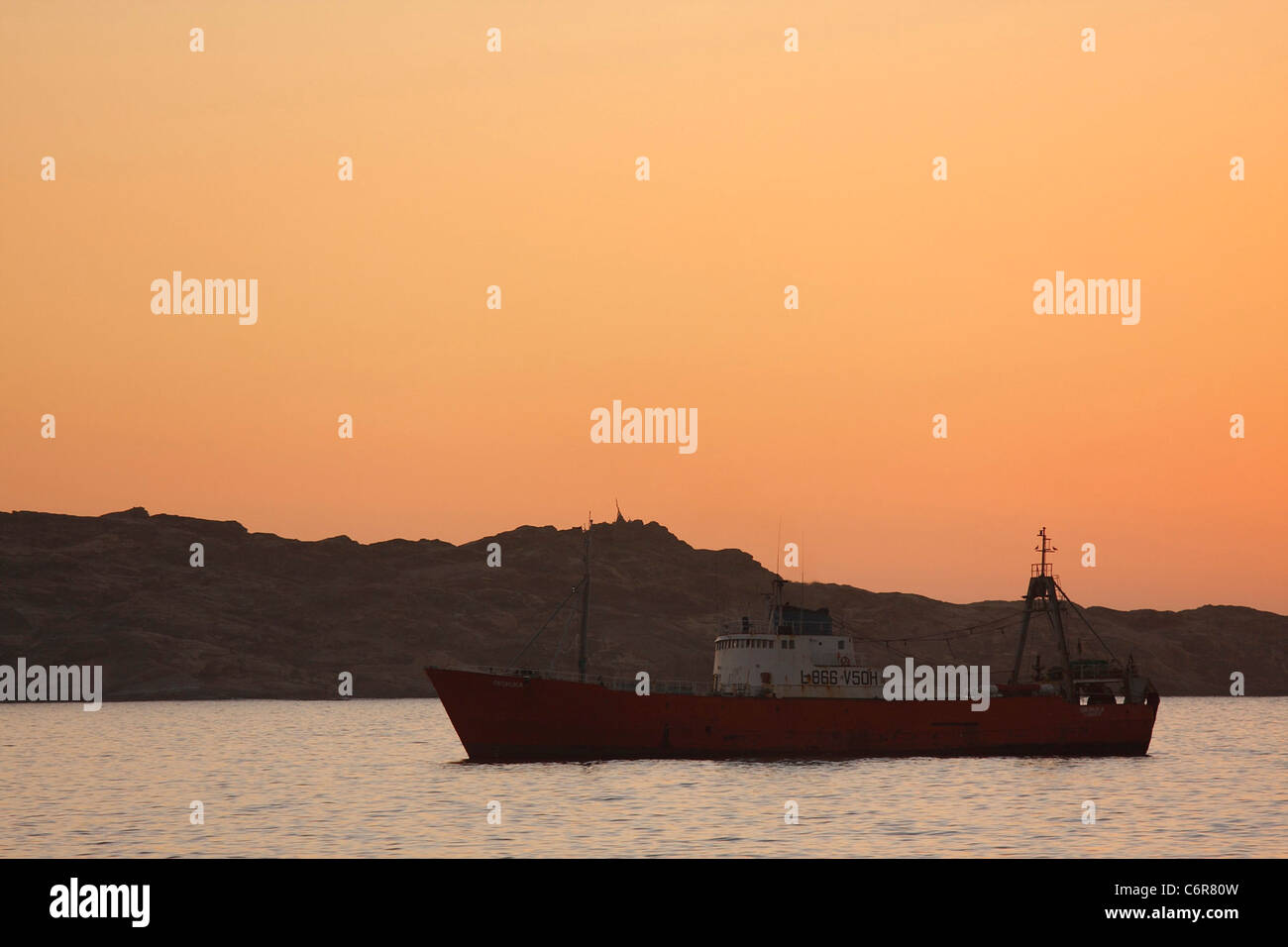 Bateau de pêche commerciale dans le port au lever du soleil Banque D'Images